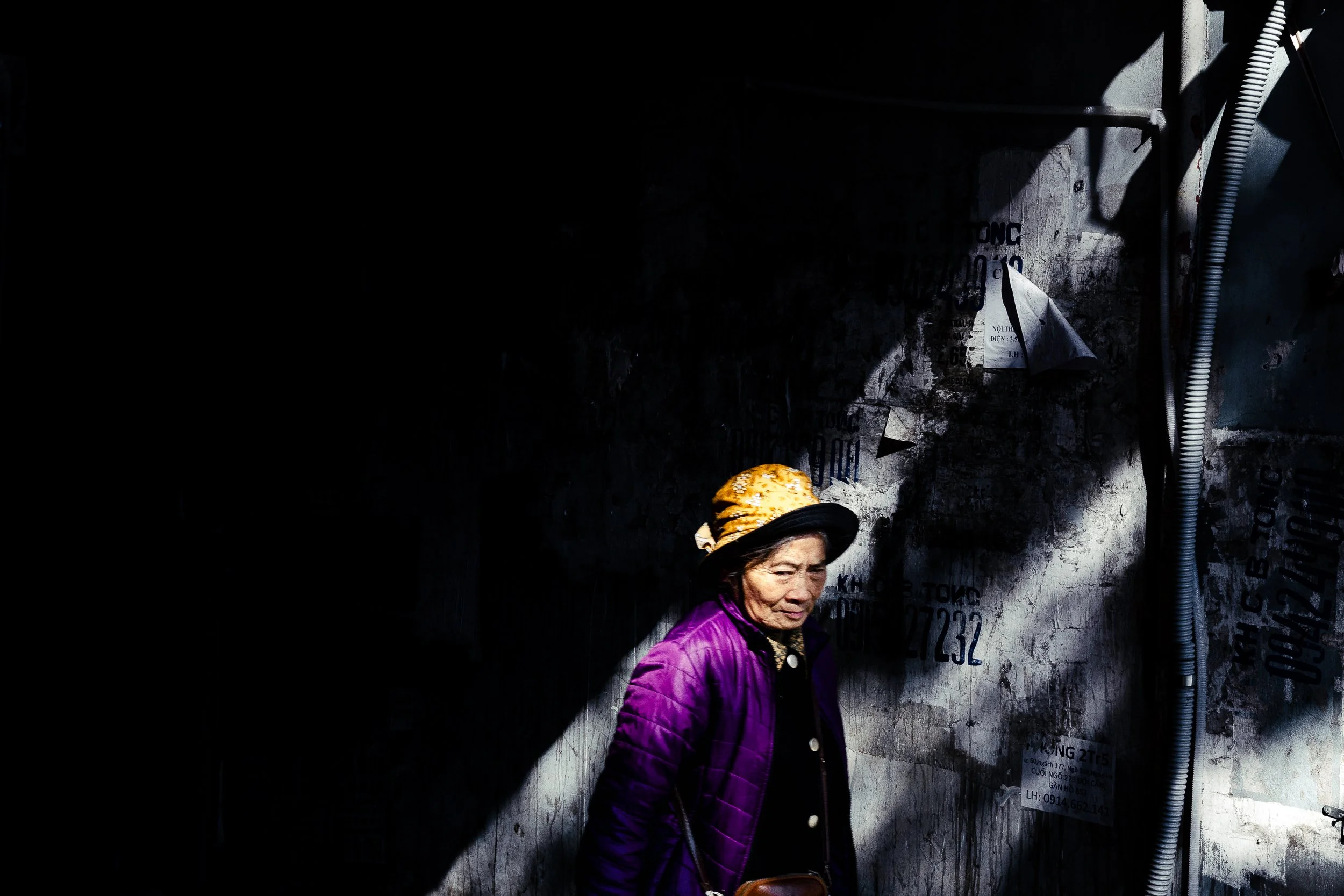 The one shaft of light, and she happened to be walking through it. Hanoi, Vietnam. 2025.