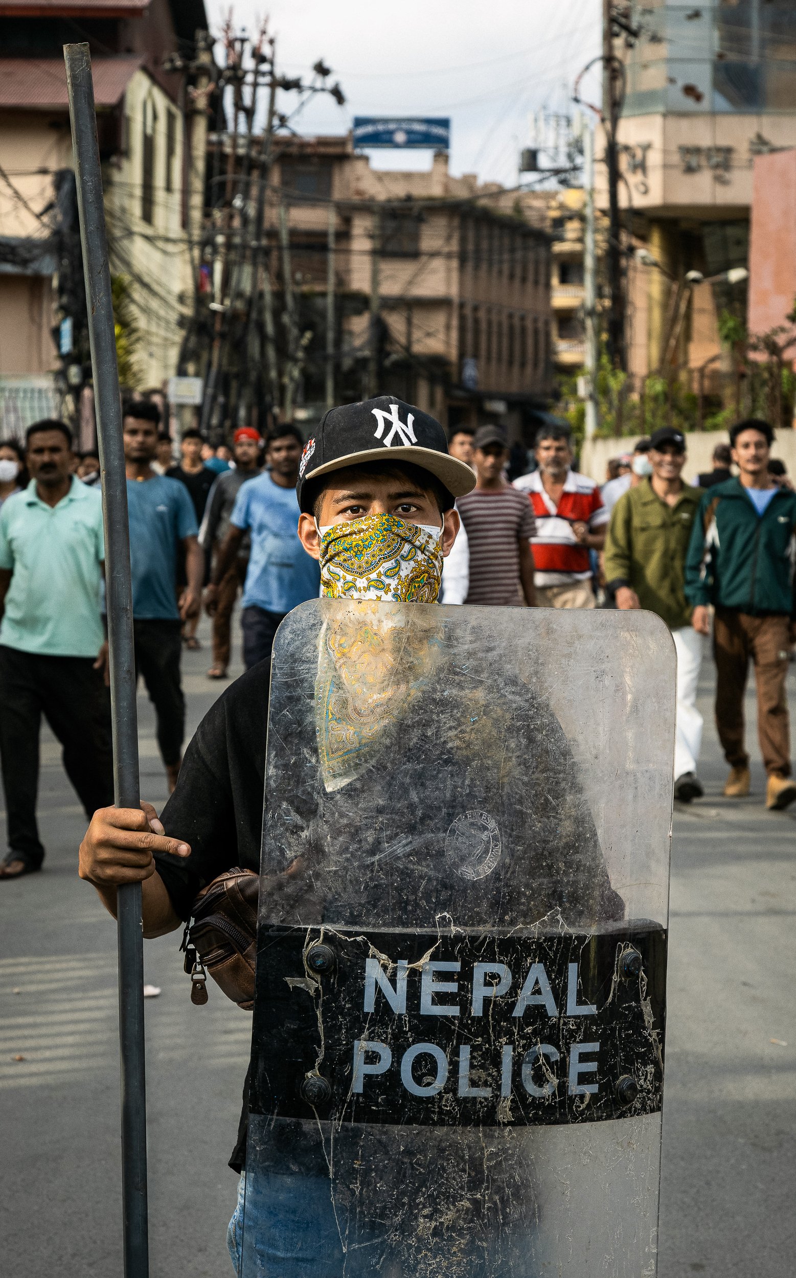 image of a protester showing a stolen police shield during kathmandhu protests