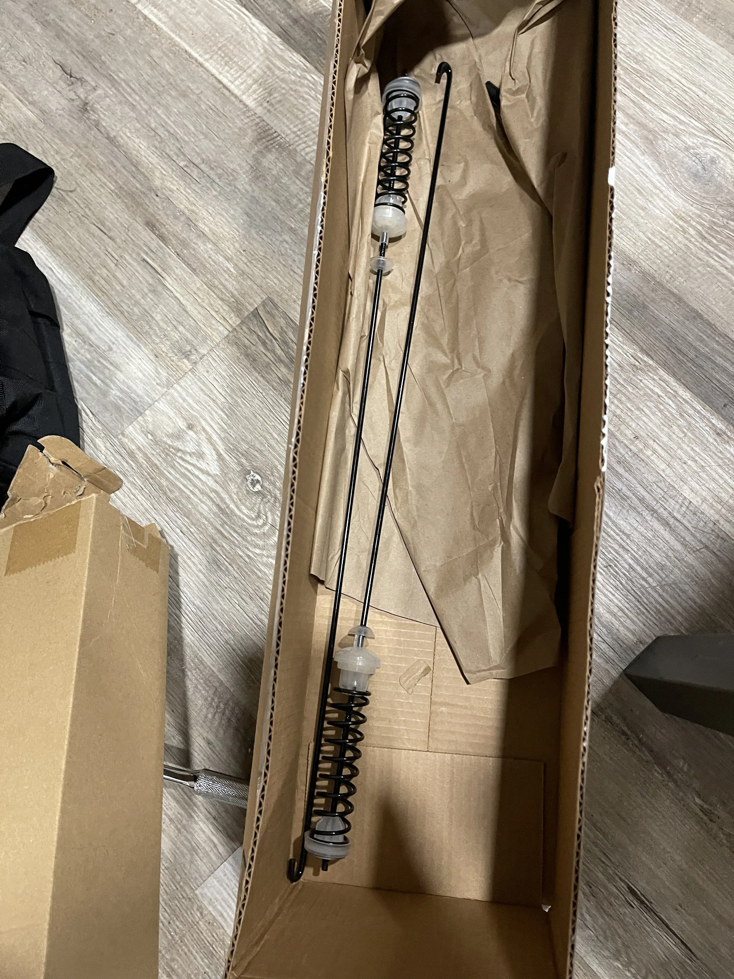 Parts in box: New washing-machine suspension rods ready for installation