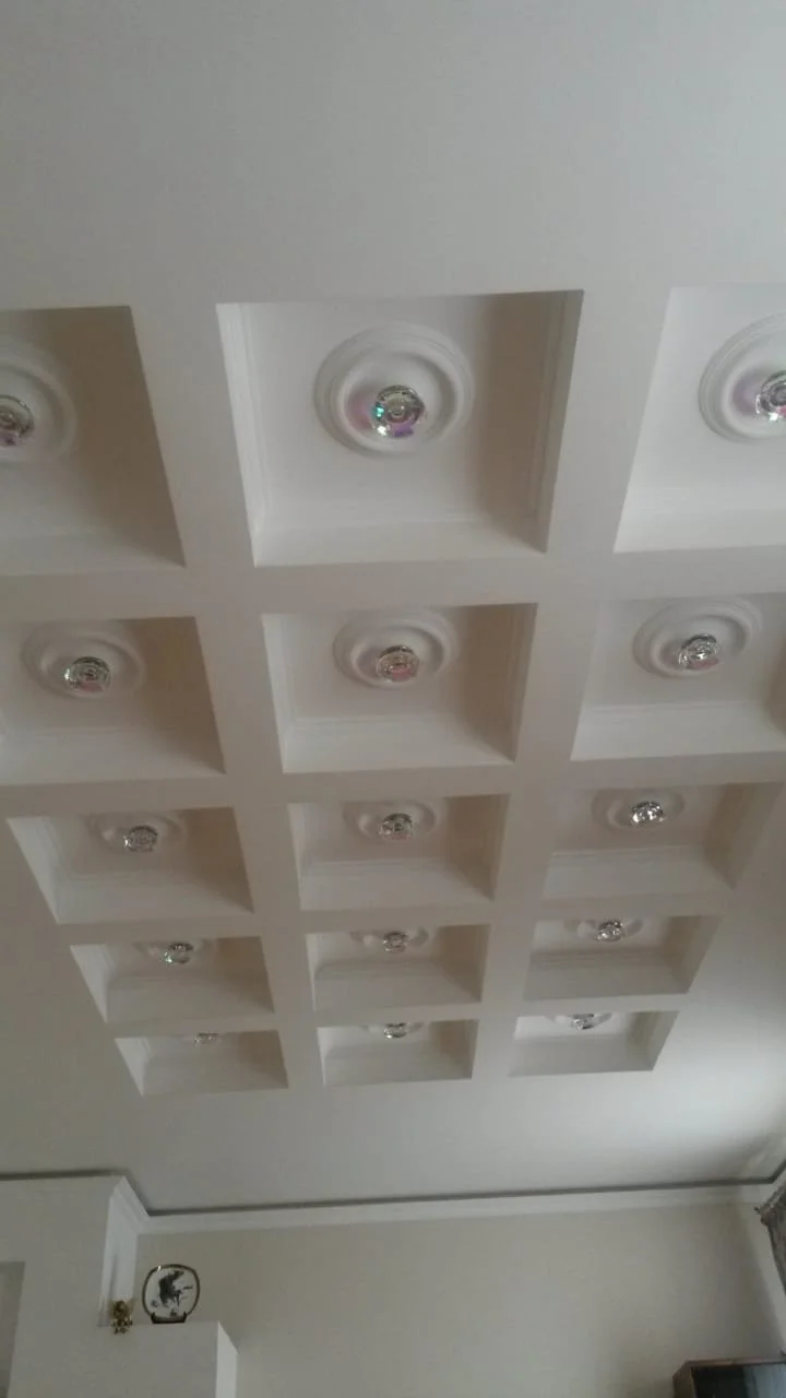 Decke mit mehreren quadratischen Einschüben und eingebauten Glühbirnen.
