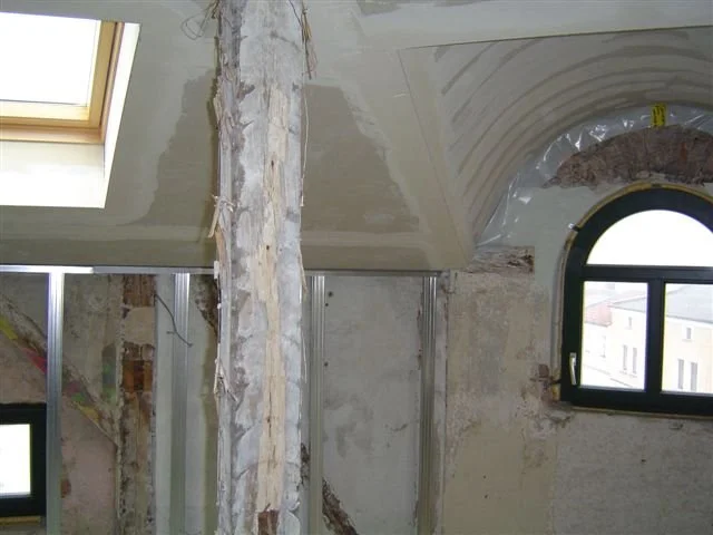 Innenraum eines Hauses im Bau, mit unvollständigen Wänden, Fenster und Dachfenster, inklusive Rohre und Baumatic-Elemente.