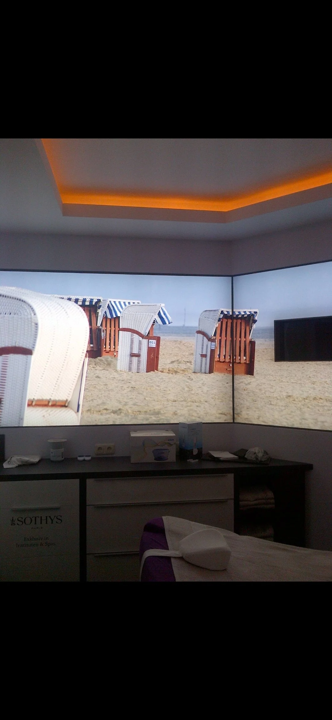 Ein Hotelzimmer mit Blick auf einen Strand mit Liegestühlen und Sonnenschirmen.