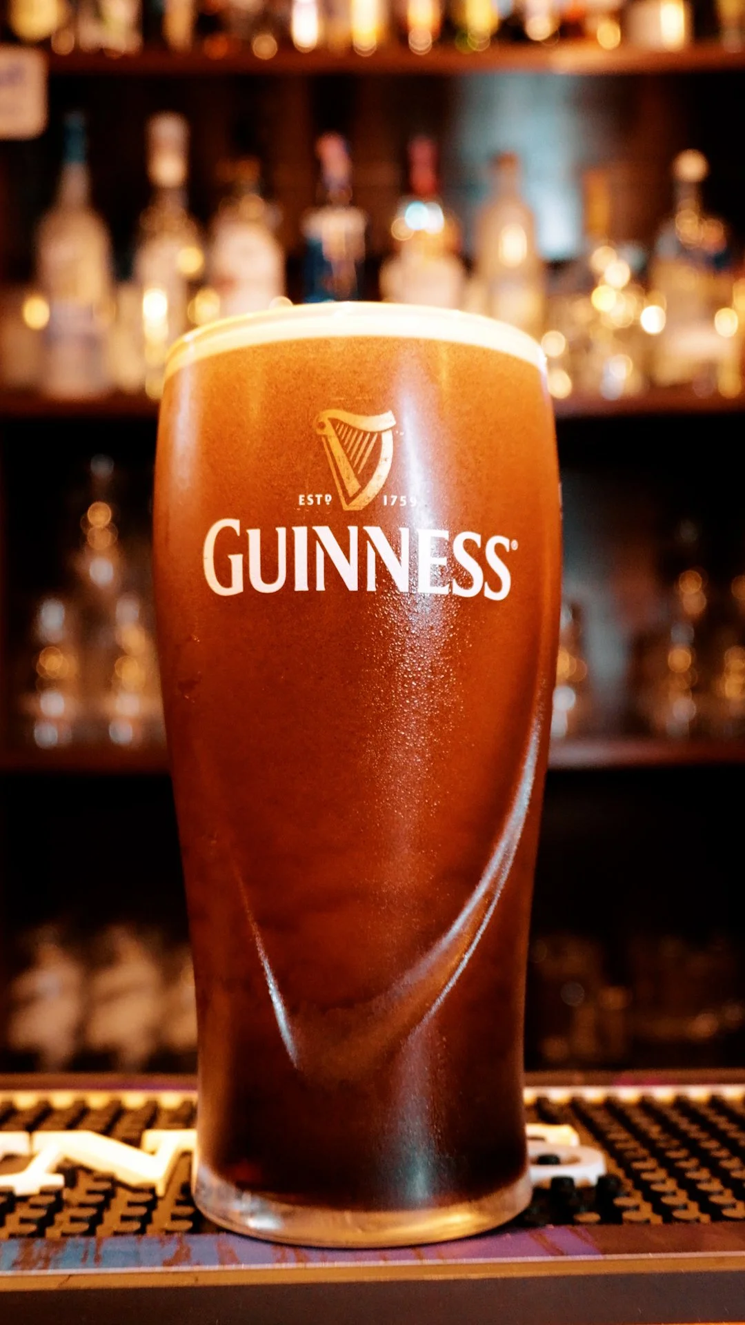 Ein Pint Guinness-Bier mit Schaumkrone auf einer Bar
