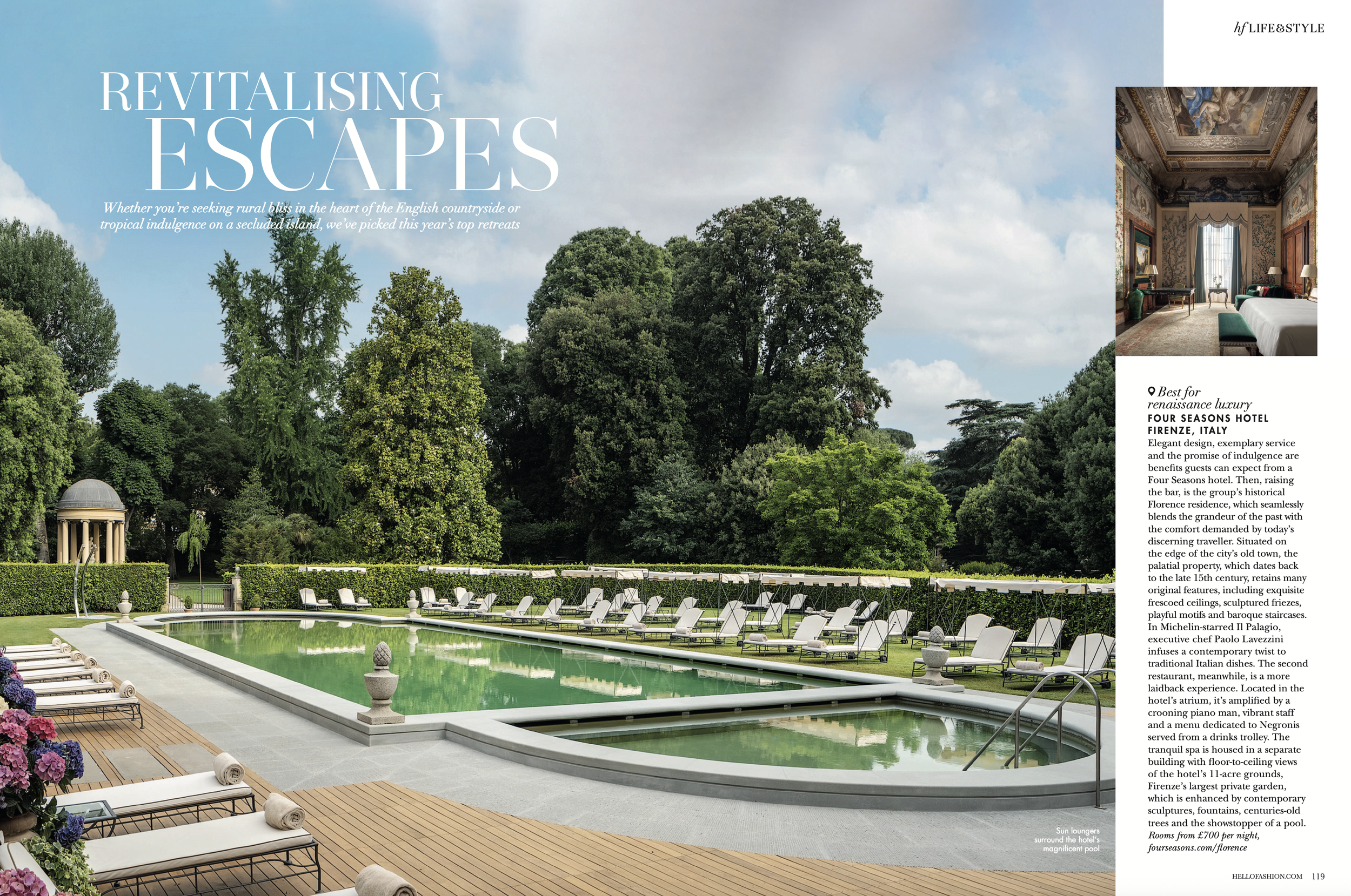 An outdoor scene of a luxurious hotel garden with a rectangular swimming pool, surrounded by lounge chairs, umbrellas, and decorative urns. Tall green trees and a classical architectural pavilion are in the background.