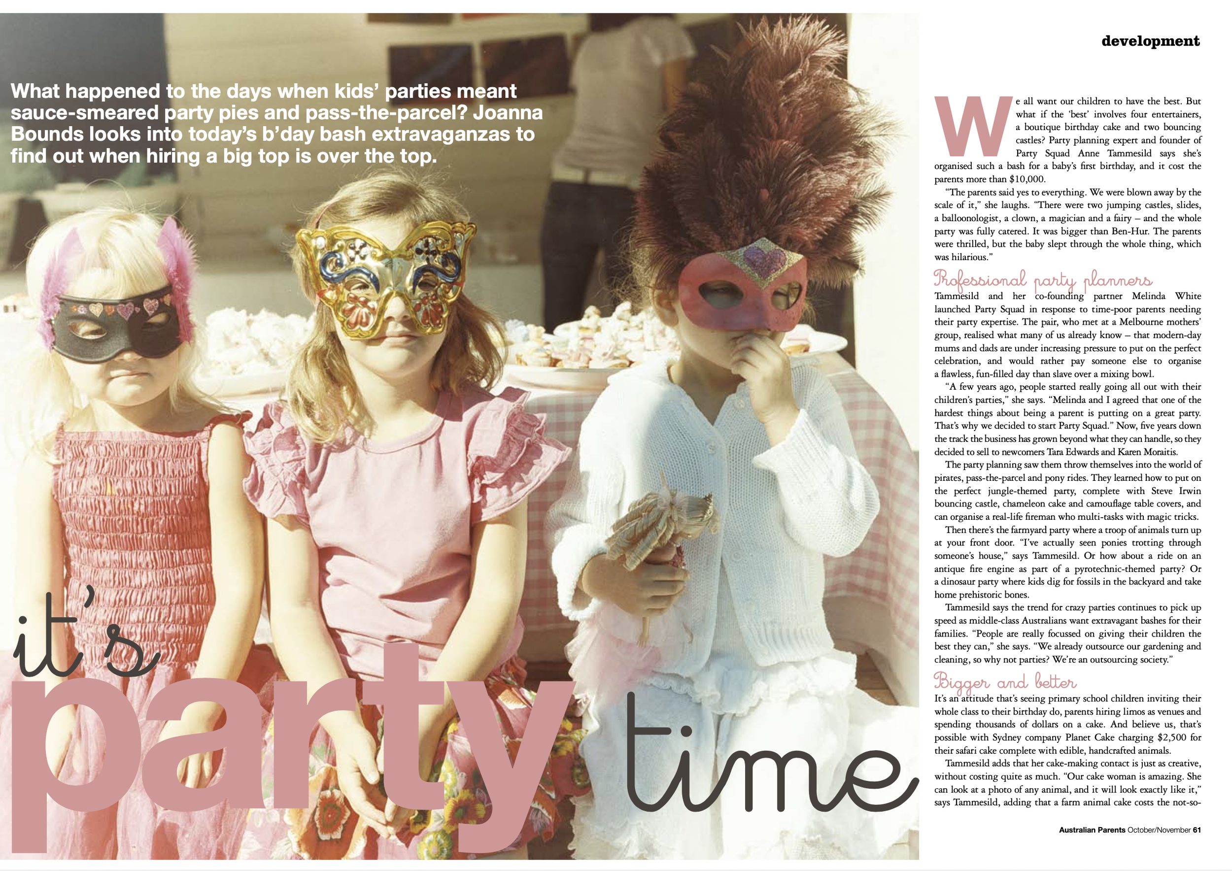 Three children at a party wearing colorful masks, standing in front of a table with snacks. The girl on the left has a mask with pink feathers, the middle girl has a butterfly-shaped mask, and the girl on the right has a pink mask with a heart design and is holding a lollipop.