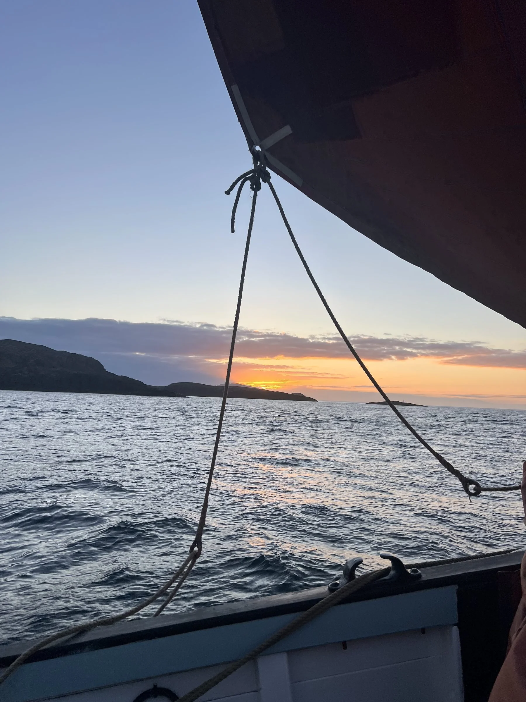 View from Provident showing a sunset over the ocean, with distant hills and a cloudy sky.
