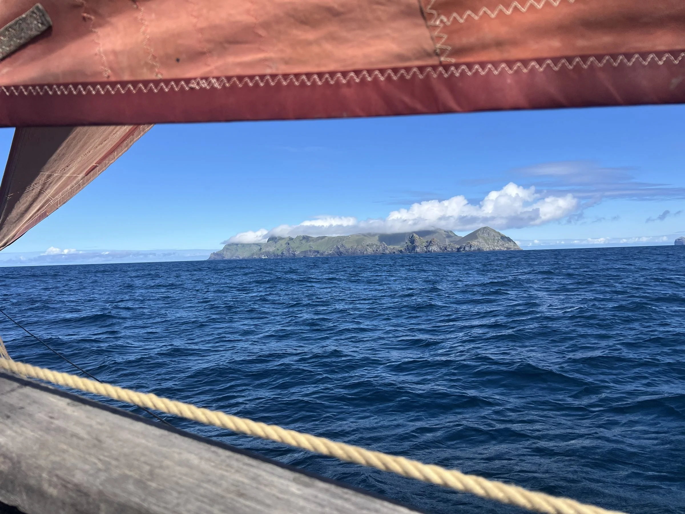 View from Provident showing blue ocean water, a distant Island of Staffa with cliffs, and a partly cloudy sky.