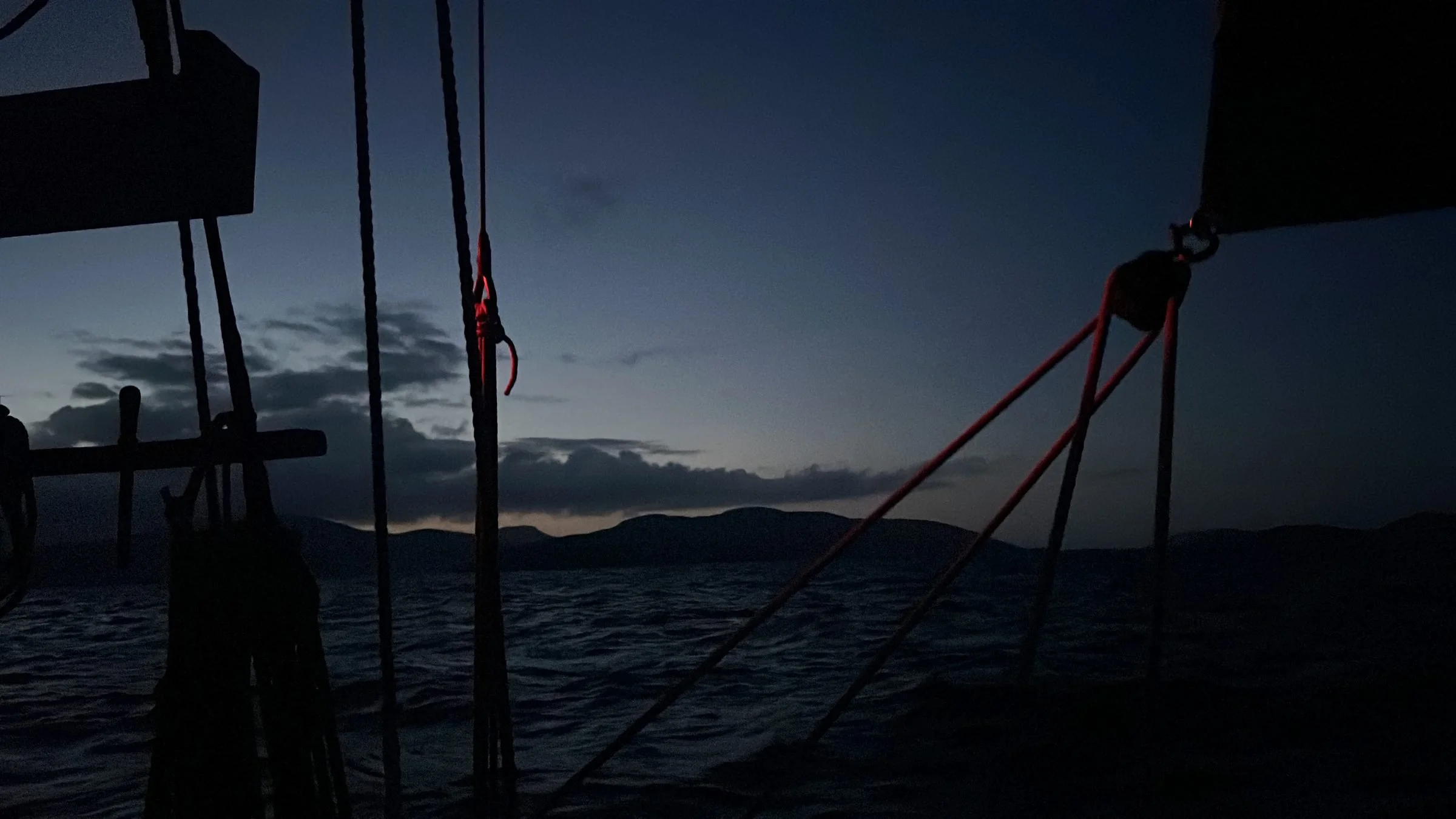 Provident against a darkening sky over water, with mountains in the background.
