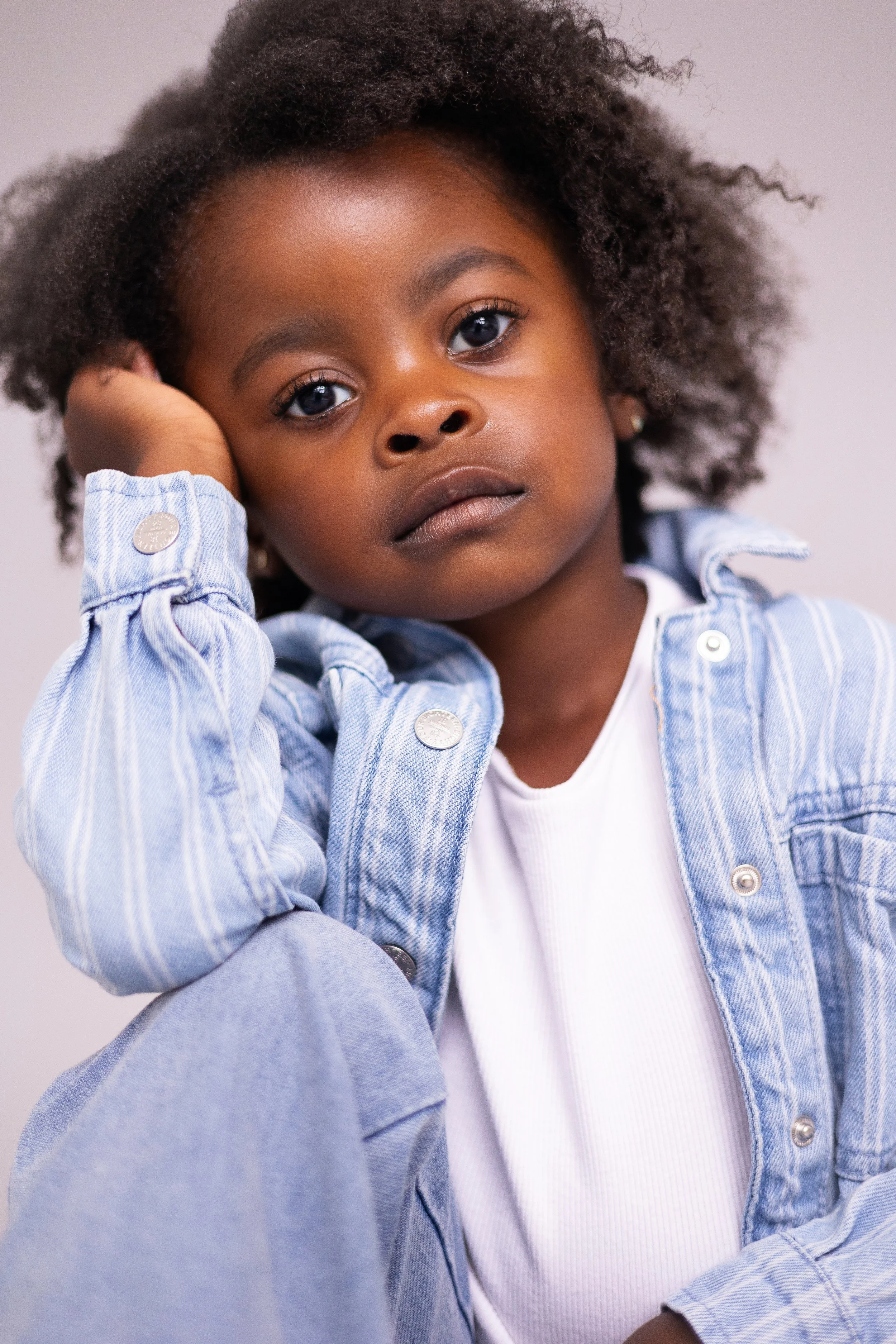 Child model portrait with a neutral expression during a natural headshot and portfolio update session.
