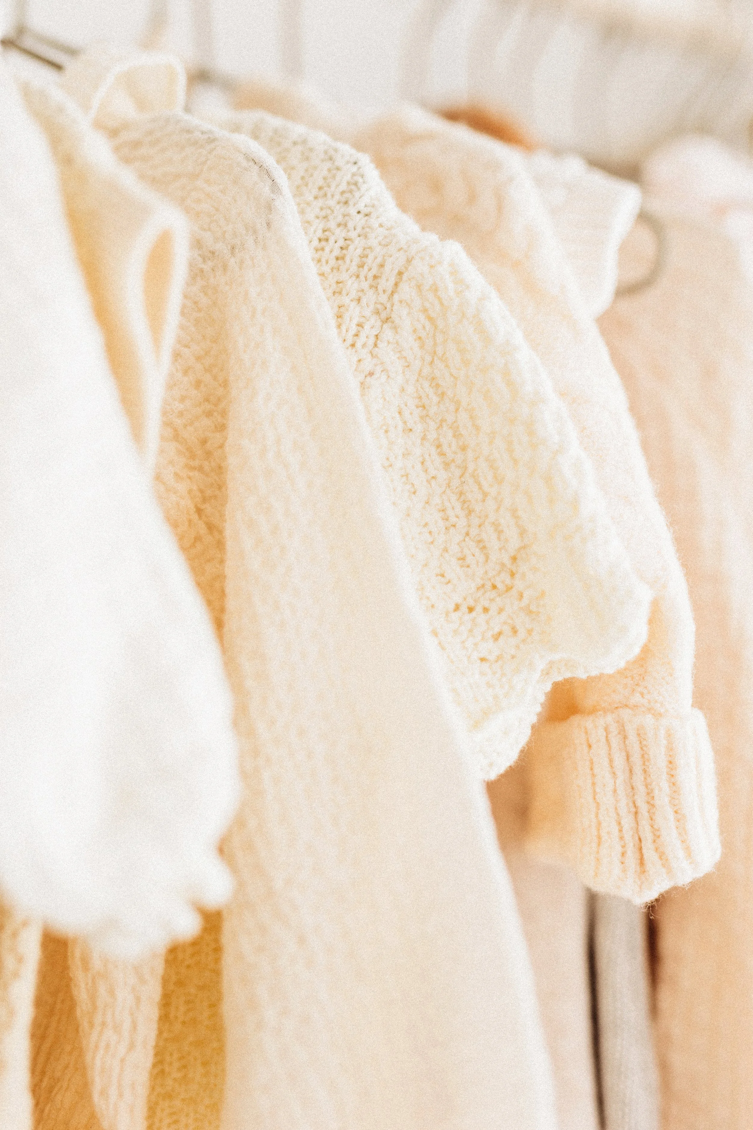 Close-up of beige and cream-colored towels hanging on a rack.