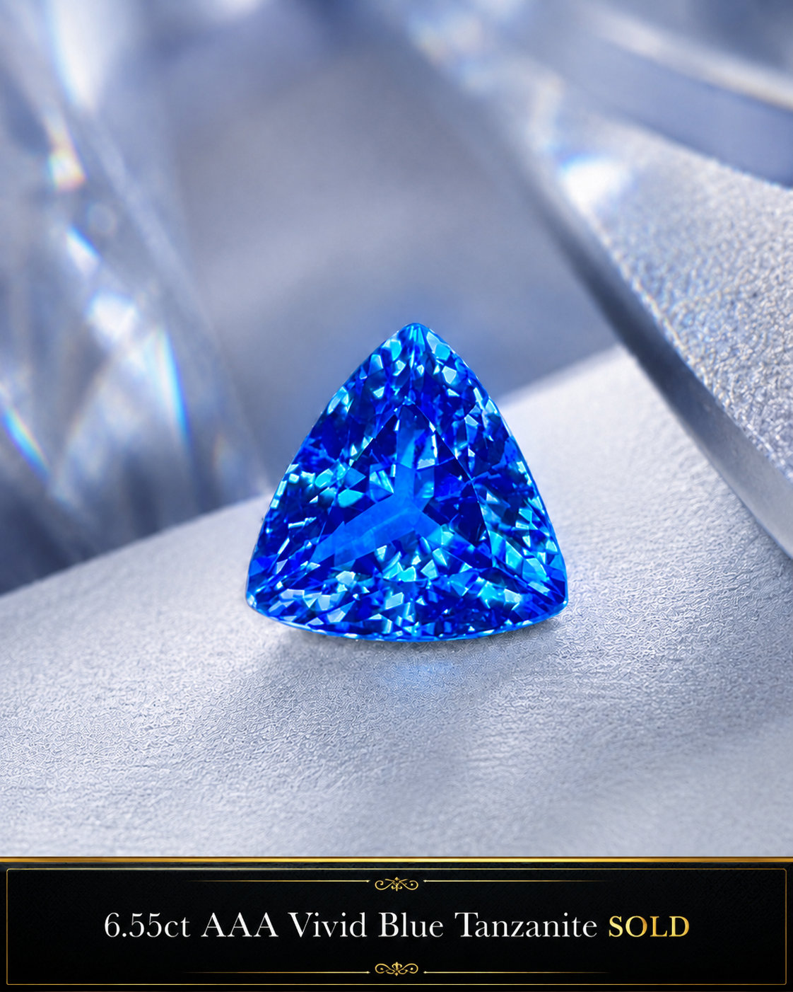 A vivid blue, trillion-cut tanzanite gemstone with a triangular shape, held in a jewelry setting.