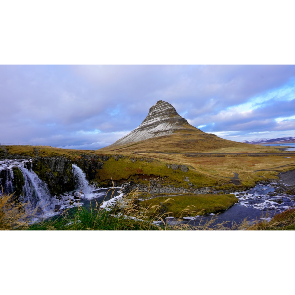 Kirkjufell mountain and Kirkjufellsfoss waterfall on Iceland’s Snæfellsnes Peninsula under soft cloudy light