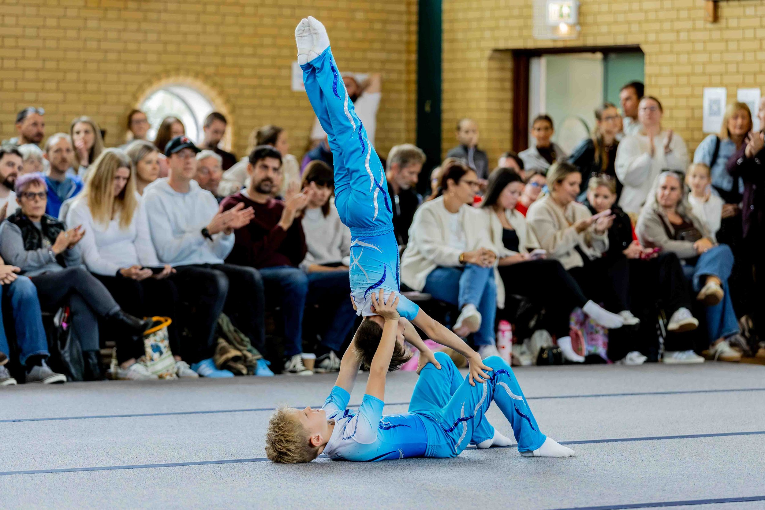 Male acro gymnasts performing balance at the Falcon Invitational competition