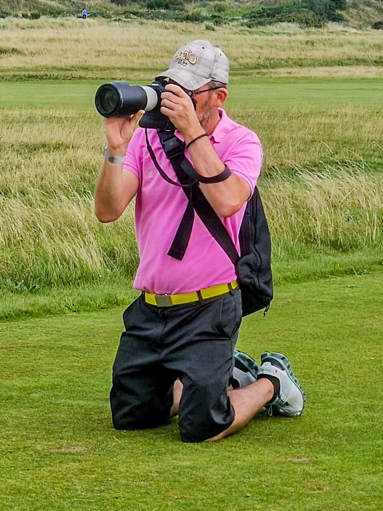 Picture of a sport photographer taking a short on a golf course