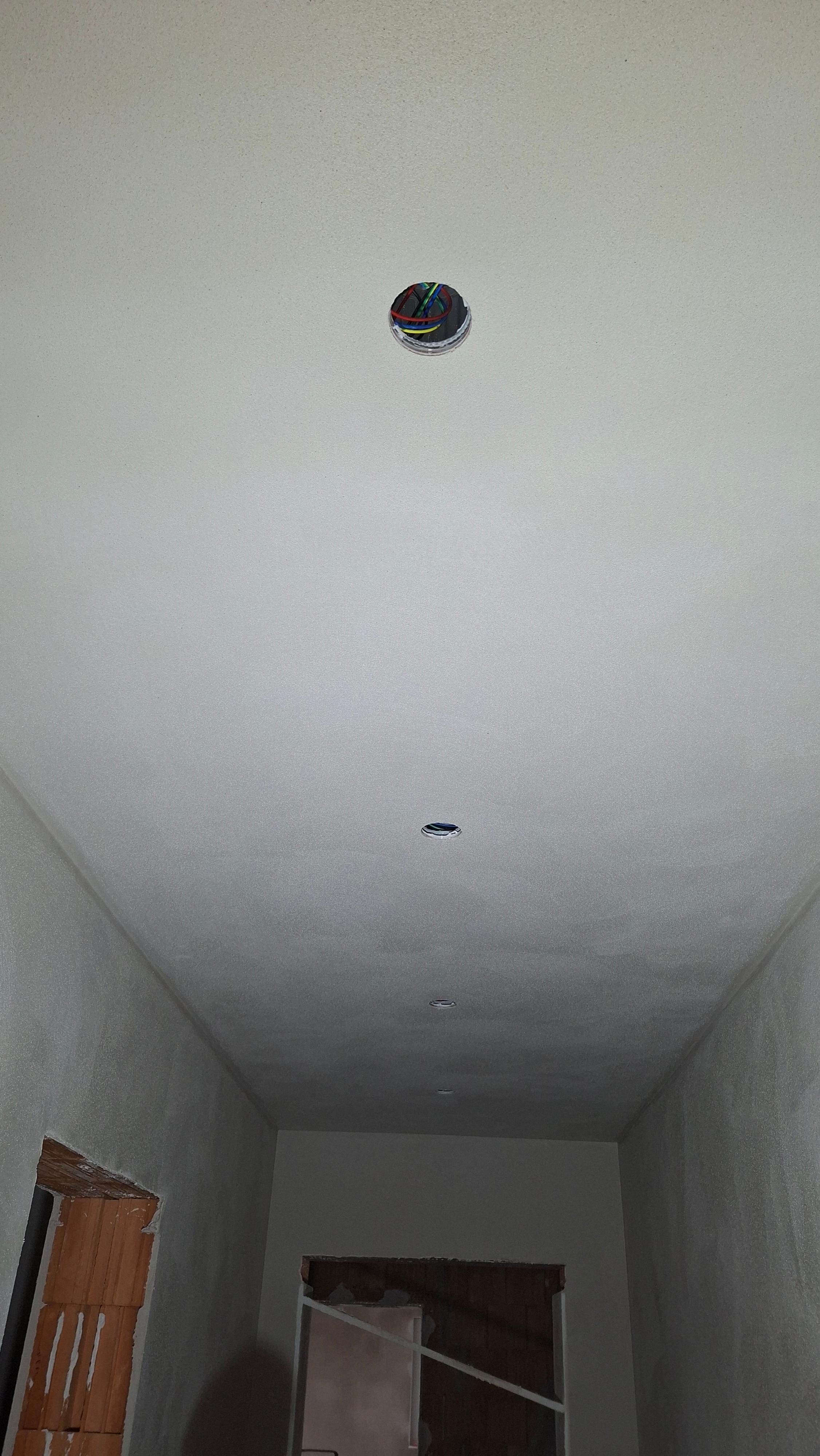 Betondecke in einem Raum mit geöffneten Auslässen für die Einbaustrahler.