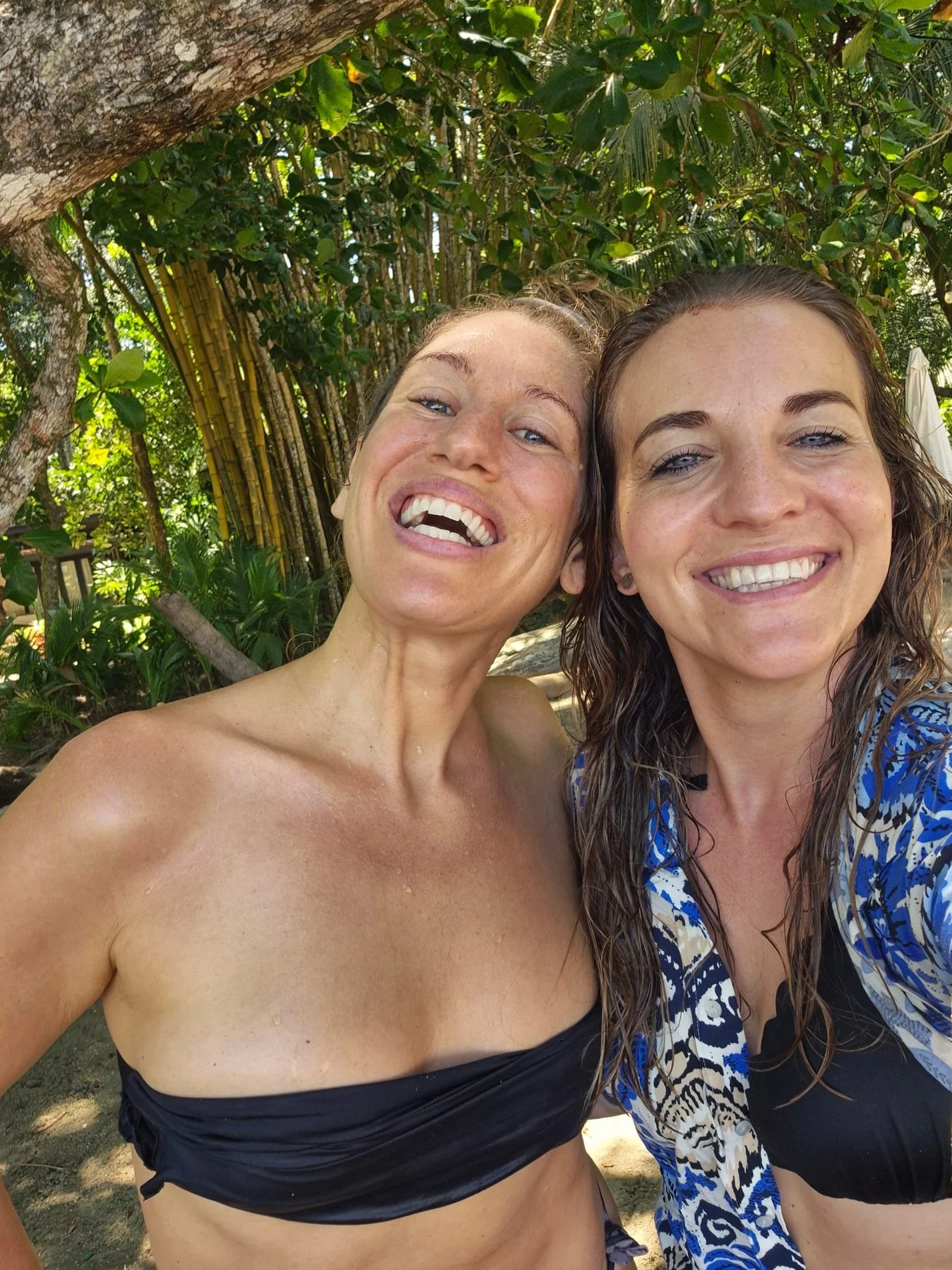 Fern Olivia and a Pure Bliss Retreat guest smiling together beneath tropical bamboo in Costa Rica