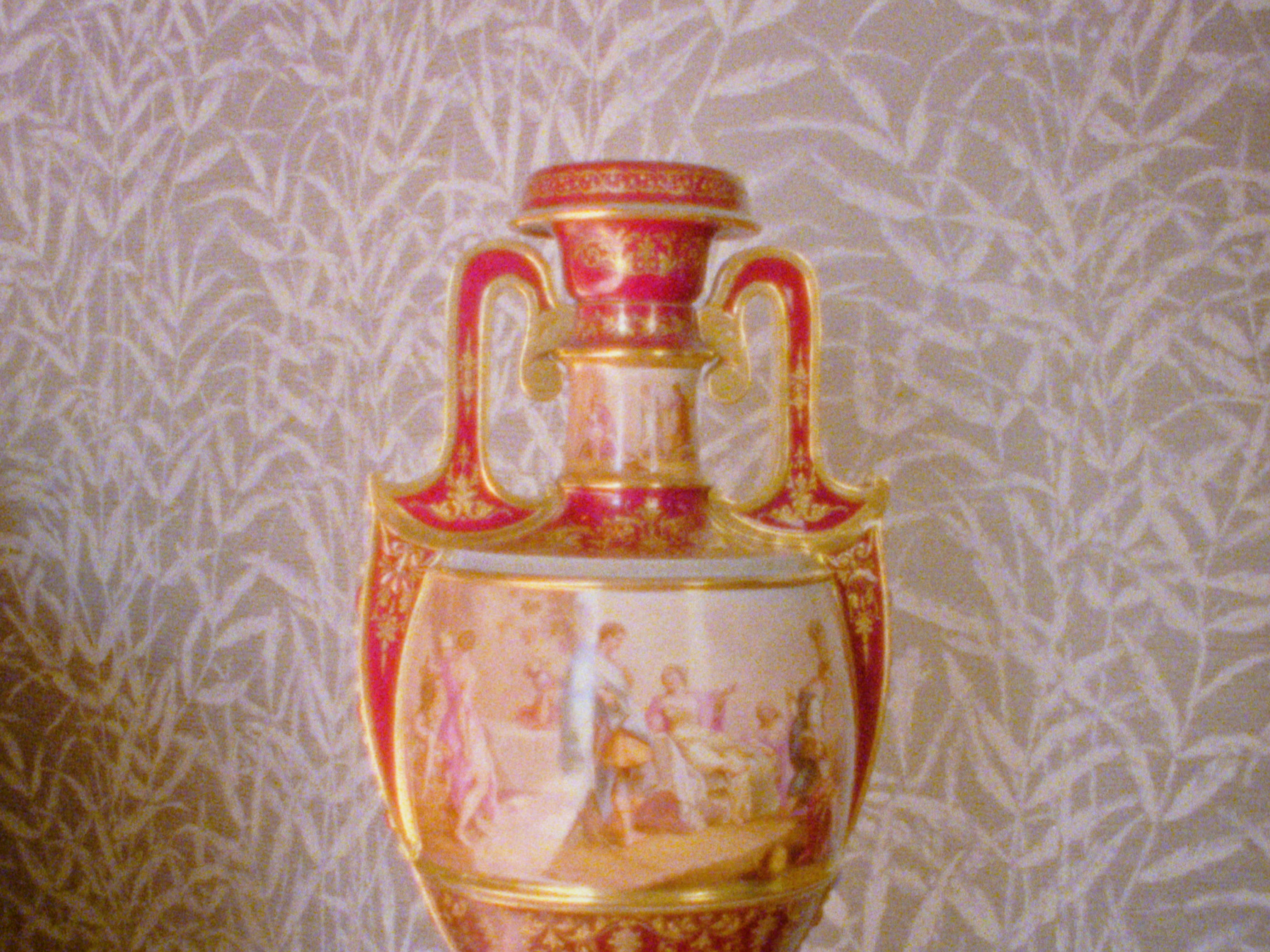 A vintage-style illustration of a trophy cup with a slender stem on a patterned background.