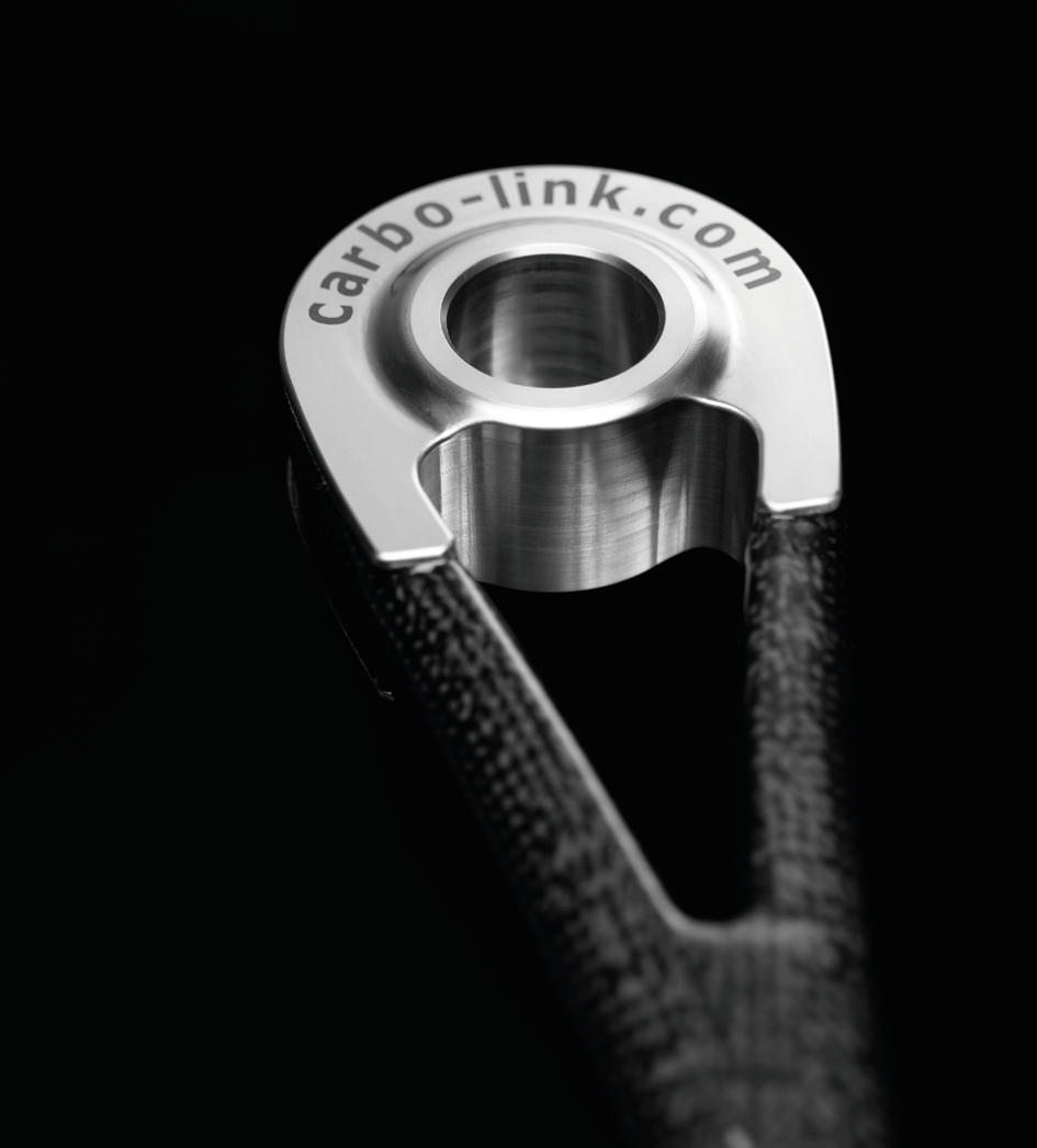 Close-up of a metal cable link with the website 'cable-link.com' engraved on it, against a black background.