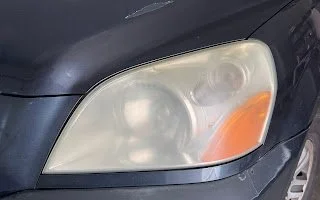 Close-up of a car's headlight with foggy and cloudy cover before headlight restoration service
