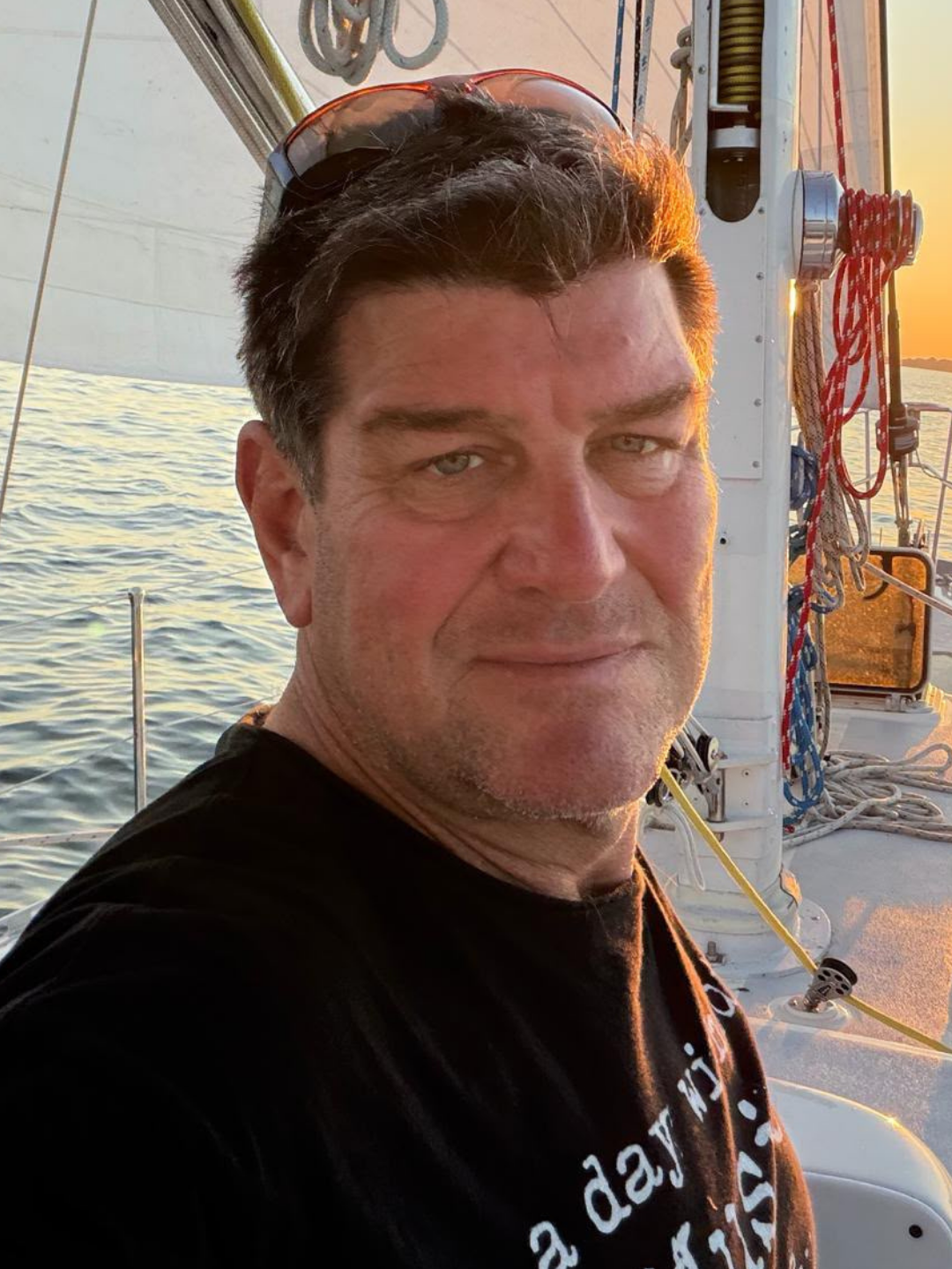Captain Elliot Nudell of Kadima Sails aboard a sailboat at sunset on the Chesapeake Bay.