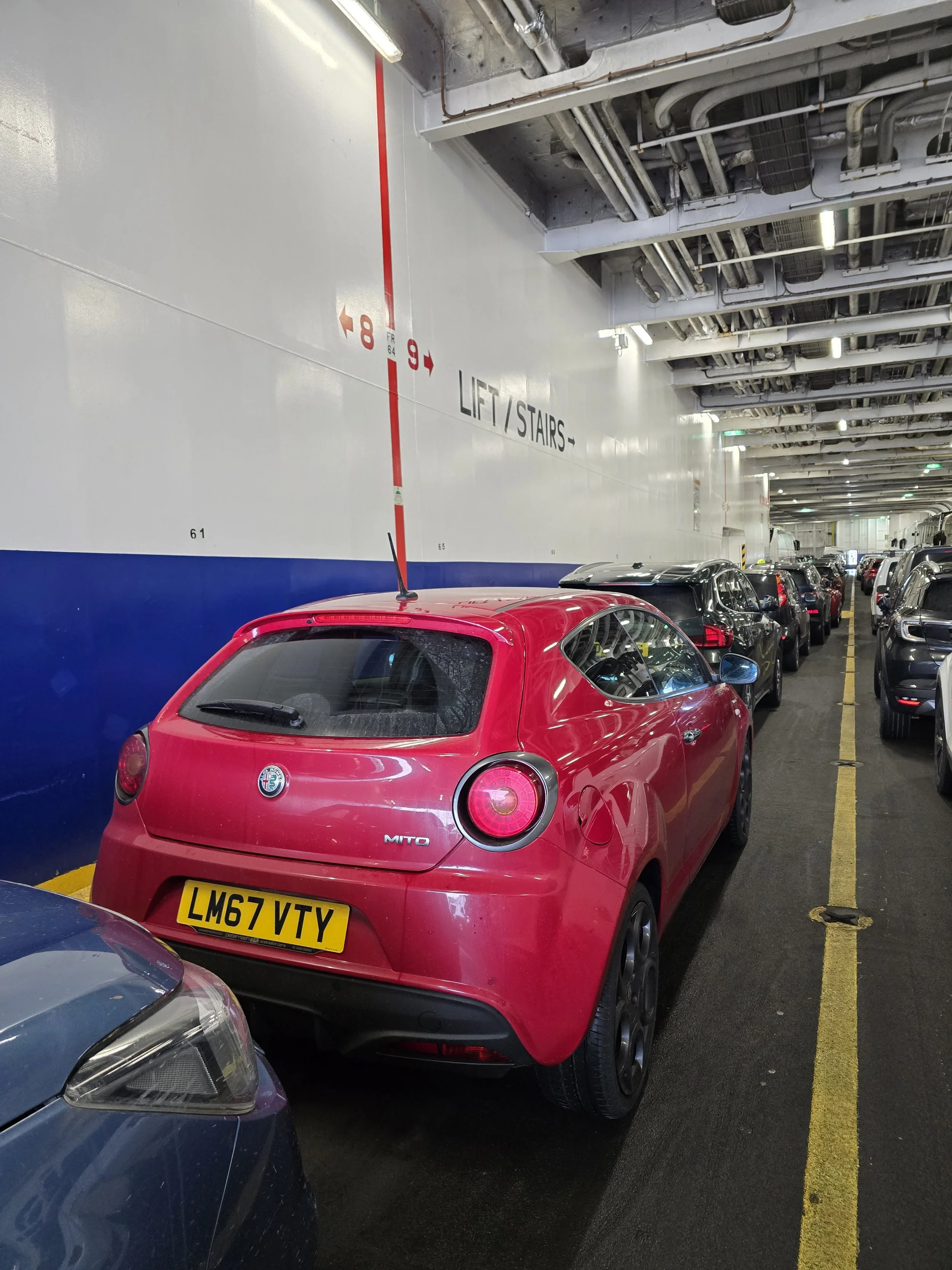 Dirty Alfa Romeo Mito parked aboard a ferry.