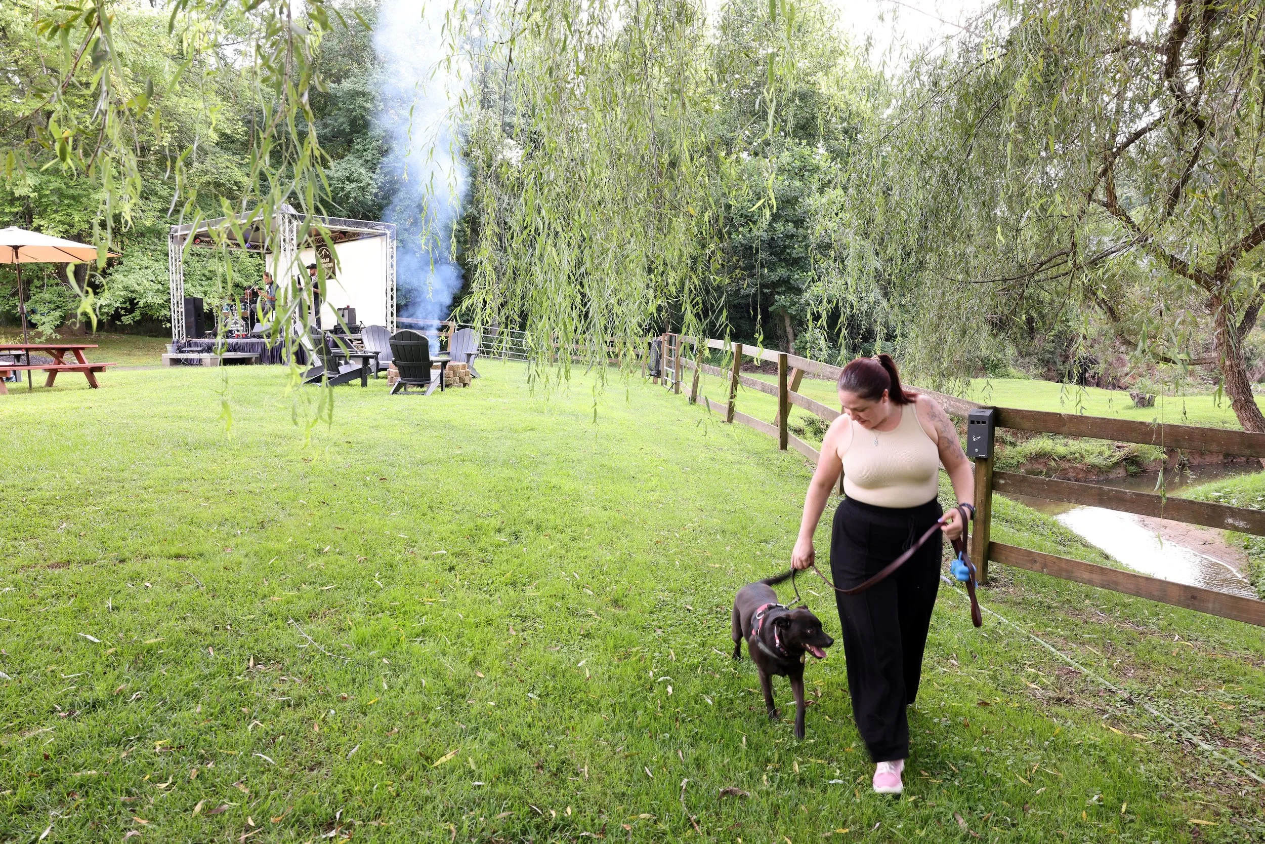 Guest walking a dog along the creek at Twin Willows.