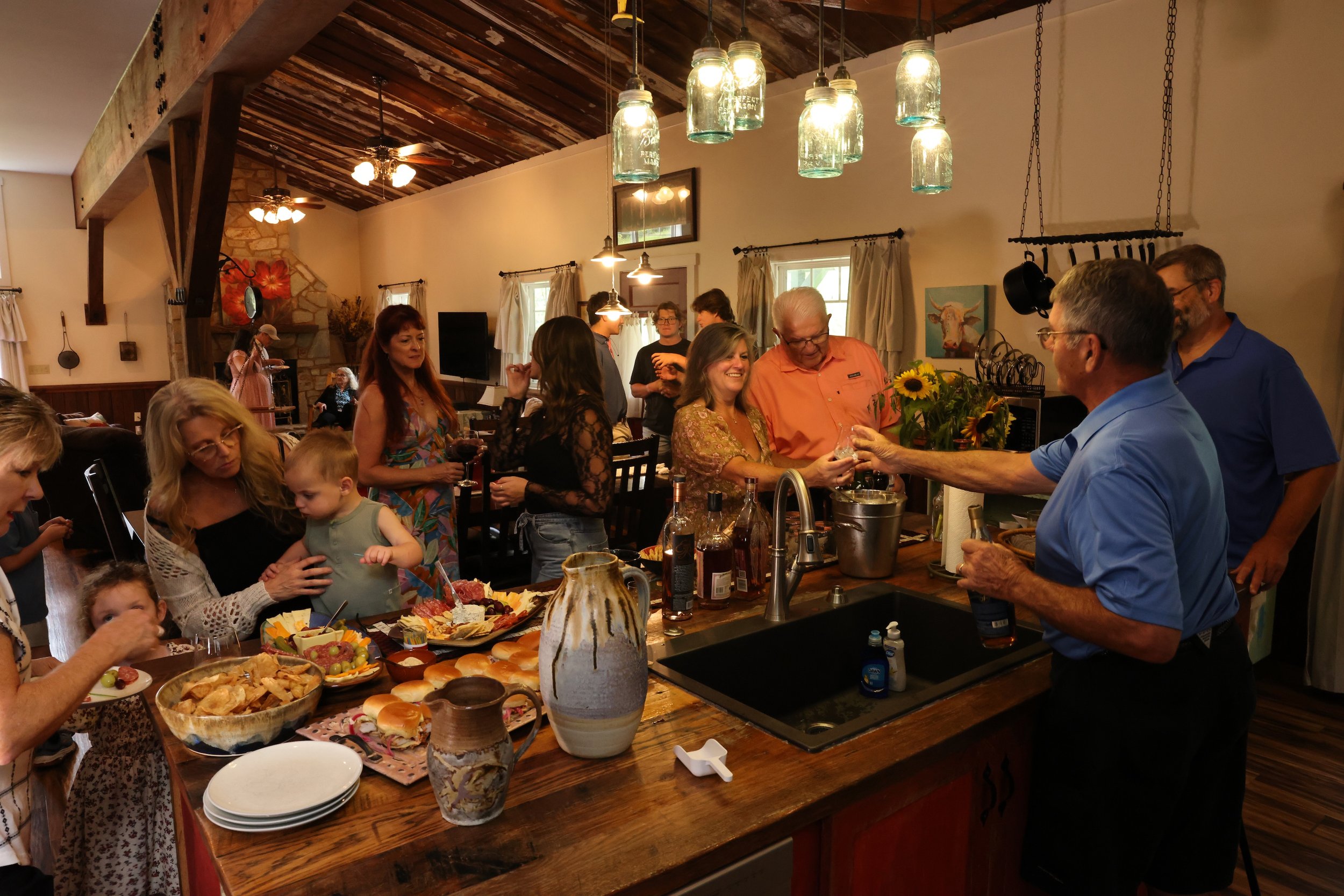 Family and friends gathering for food inside the Stable House at Twin Willows.