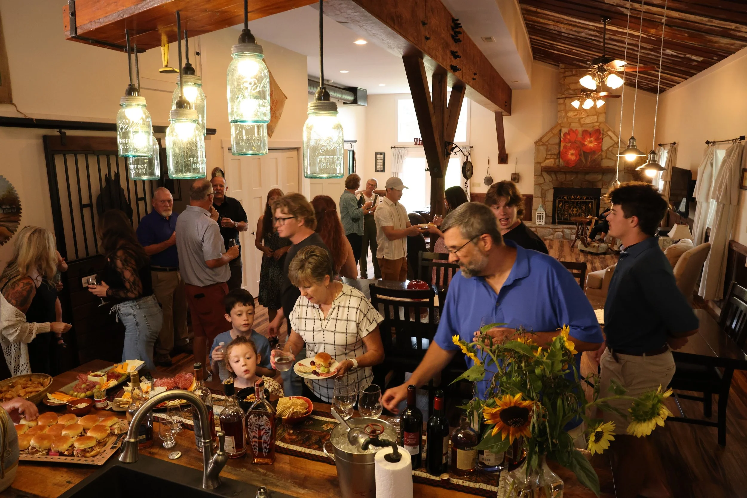 Family and friends gathering for food and drinks inside the Stable House at Twin Willows.