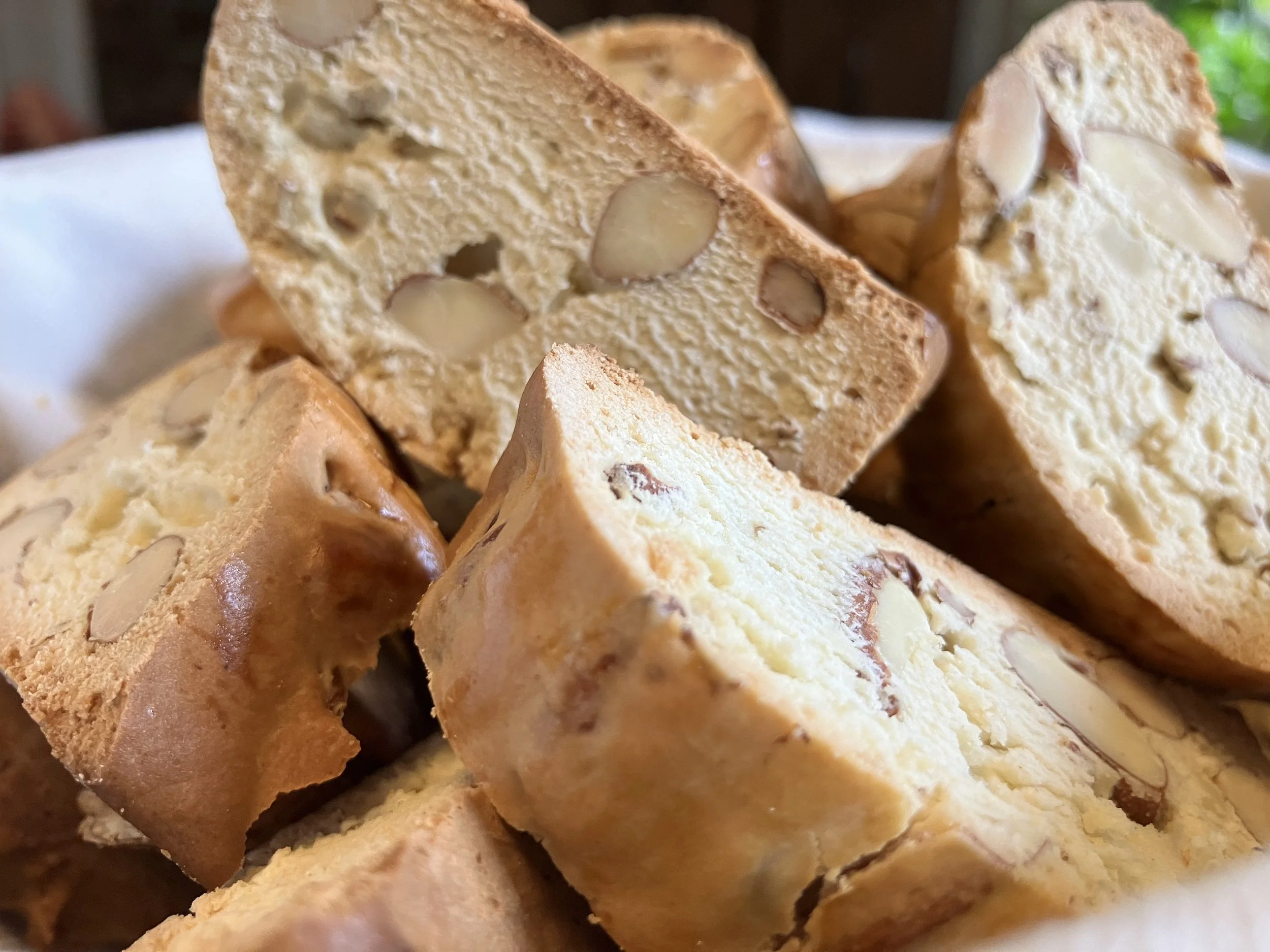 Close-up of slices of almond biscotti arranged in a pile, showing the crunchy texture and embedded almonds.