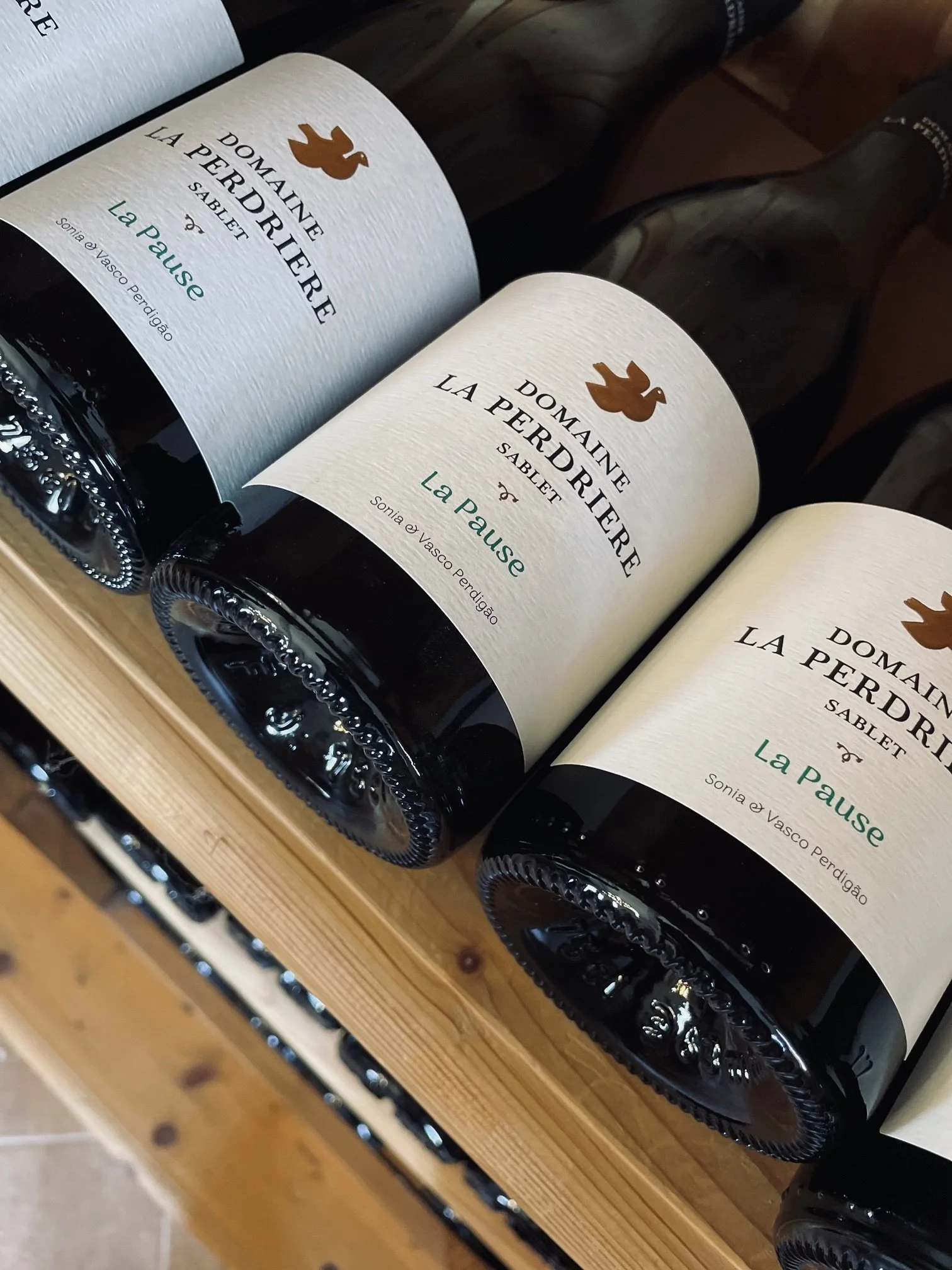 A display of bottles of La Pousse wine on a wooden shelf.