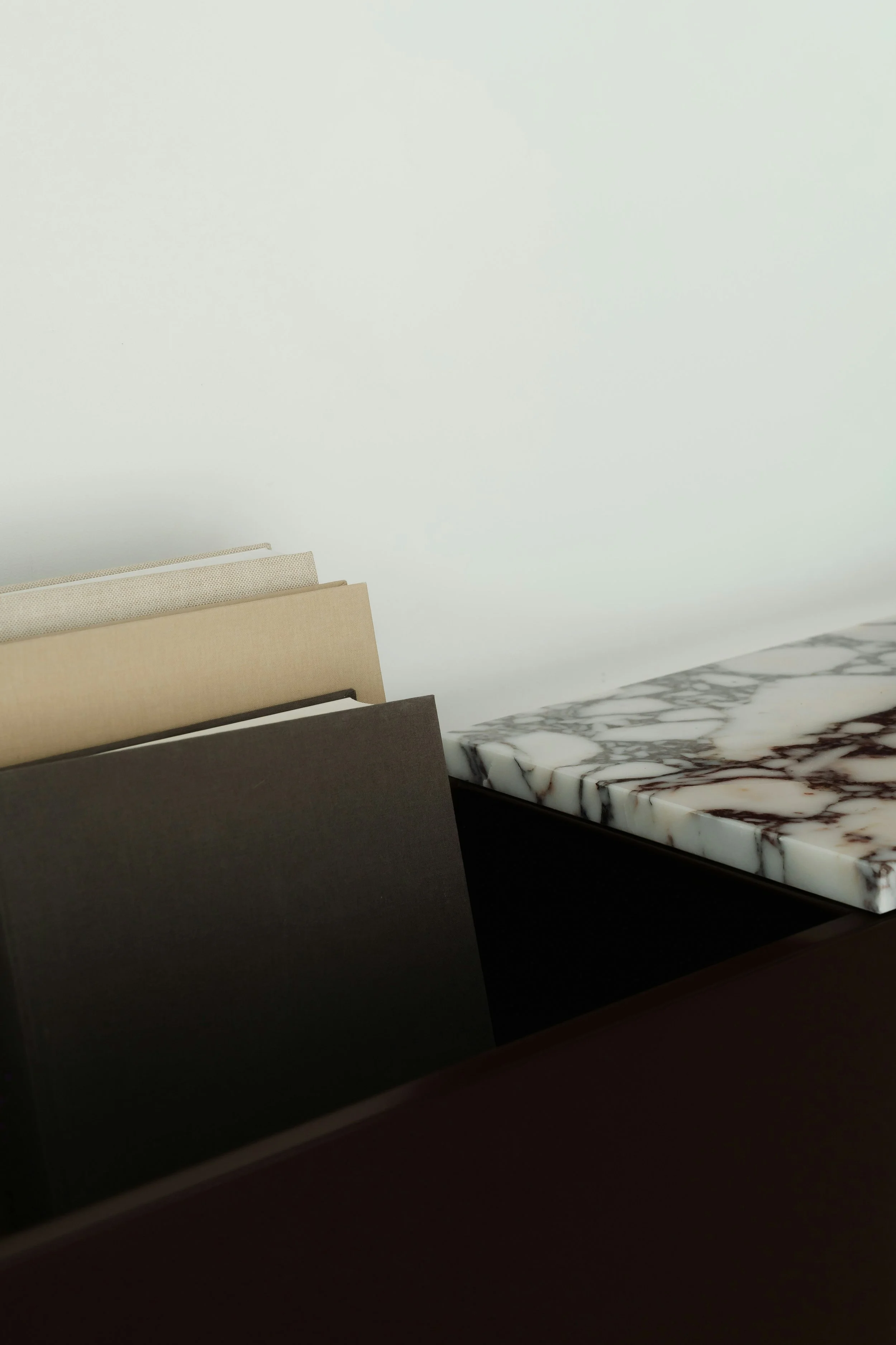 Stacked fabric sample cards in beige, light gray, dark gray, and dark green, with a marble-patterned surface in the background.