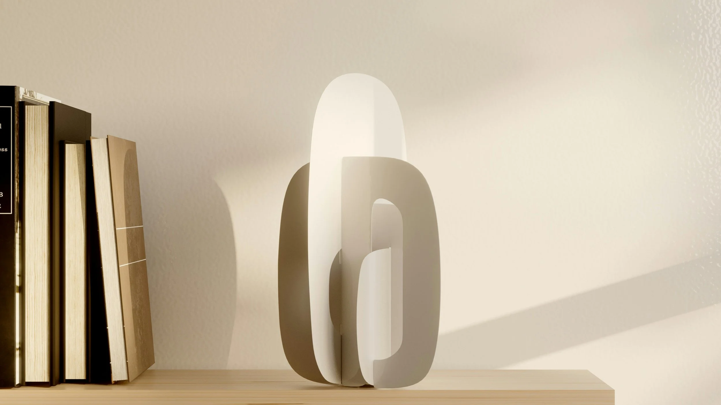 Books leaning against a white wall with shadowed text sculpture spelling 'love' on a wooden surface.