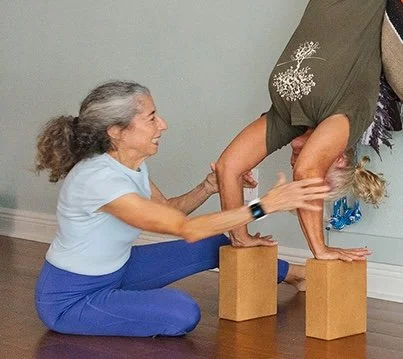 Instructing a student in the arm actions of rope Sirsasana