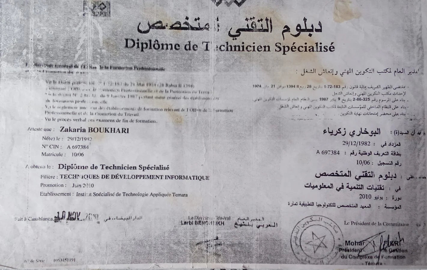 Photograph of a Moroccan technical diploma document with Arabic and French text, including a stamp, signatures, and a date.