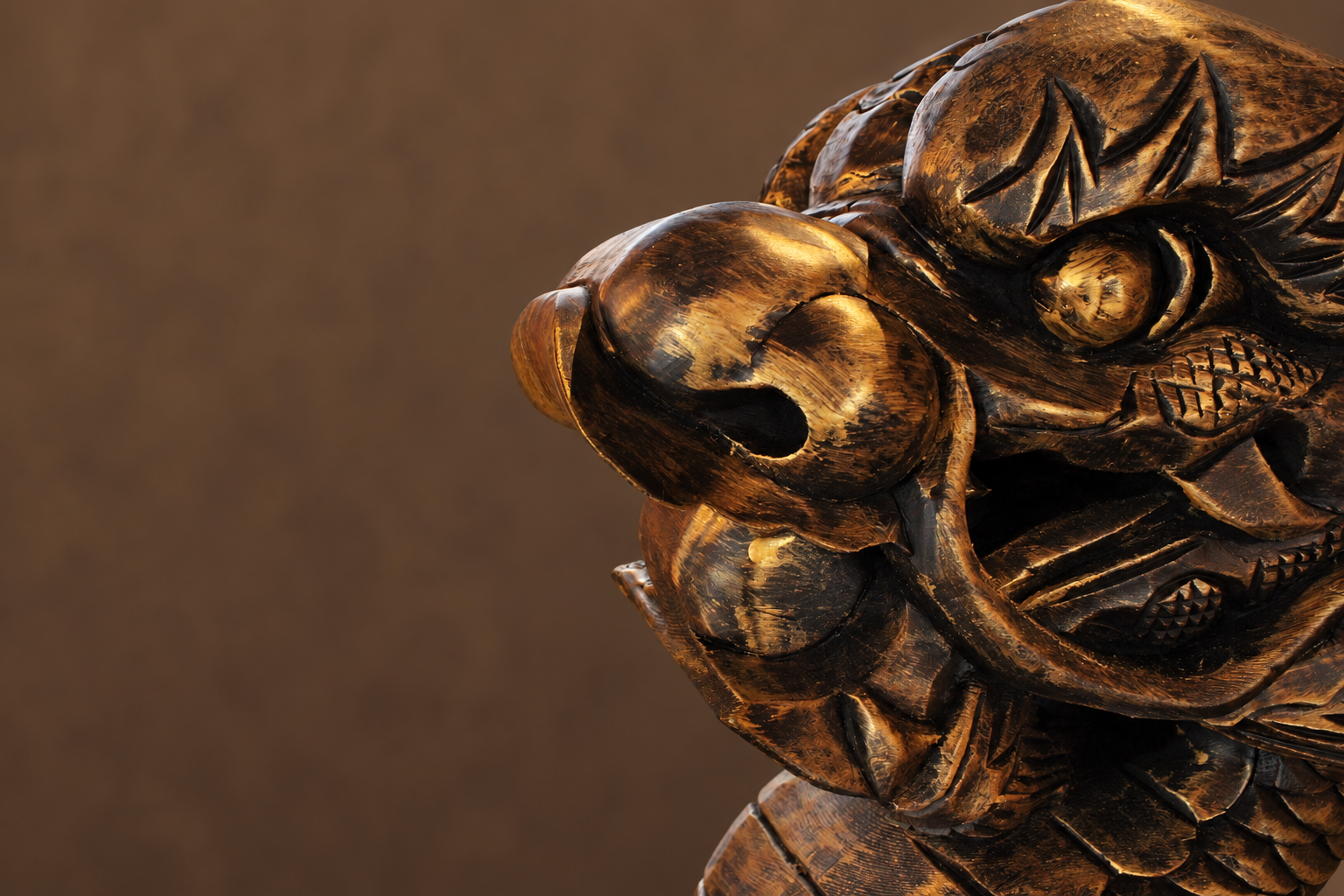Close-up of a carved wooden tiger sculpture showing detailed facial features.