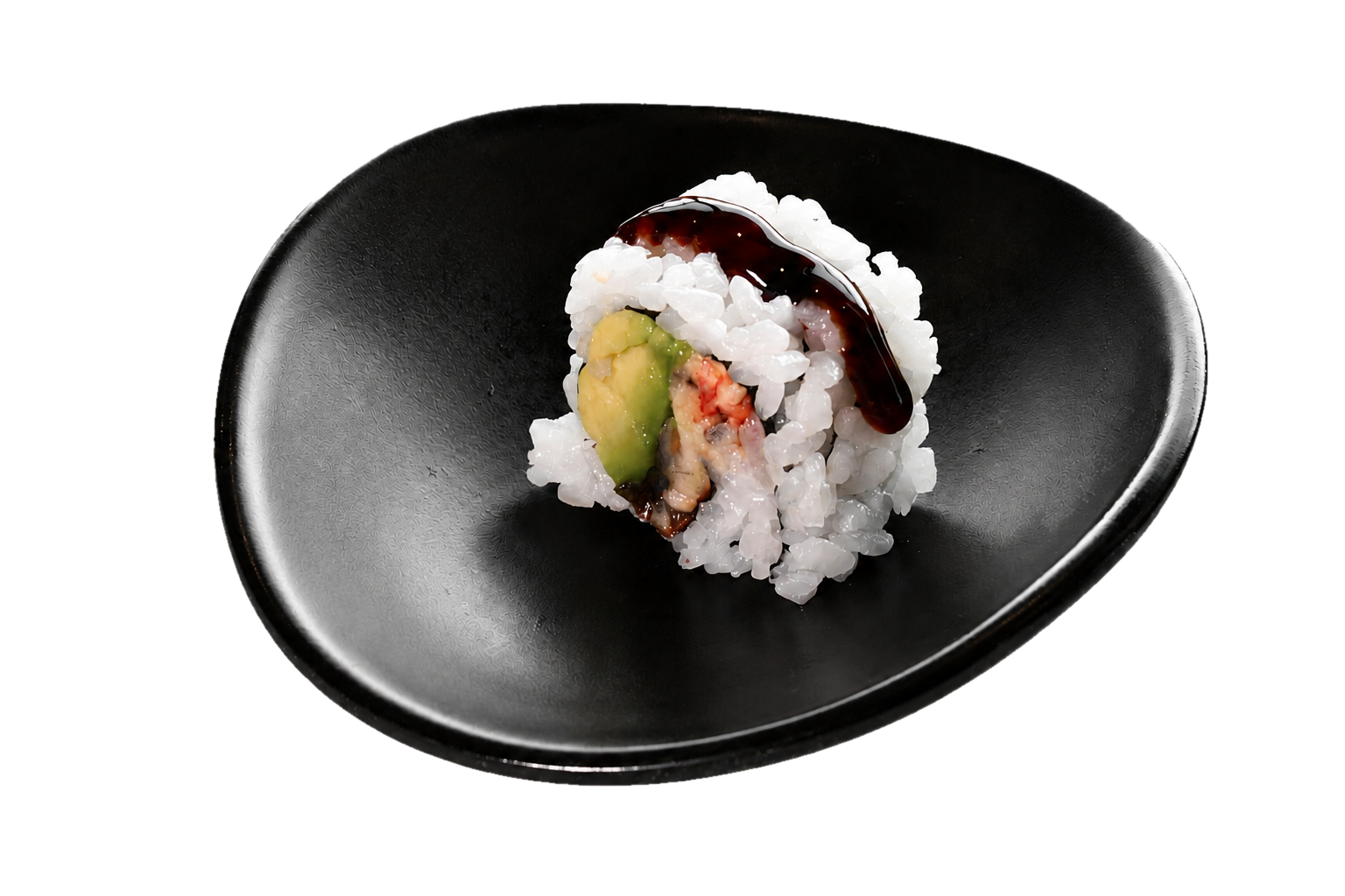 A piece of sushi with rice, avocado, and fish, topped with eel sauce, on a black dish.