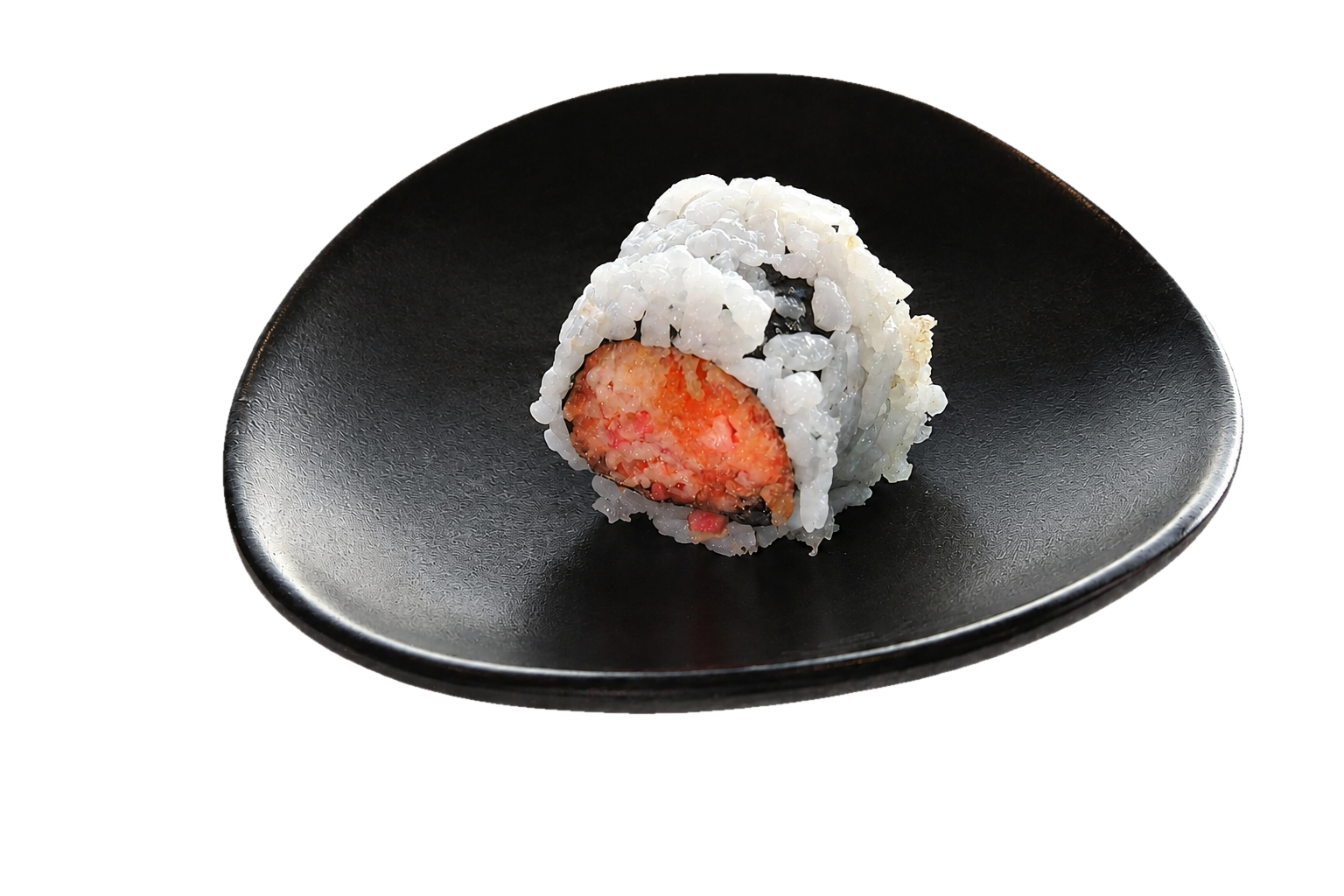 A sushi roll with white rice and an orange filling on a black plate.