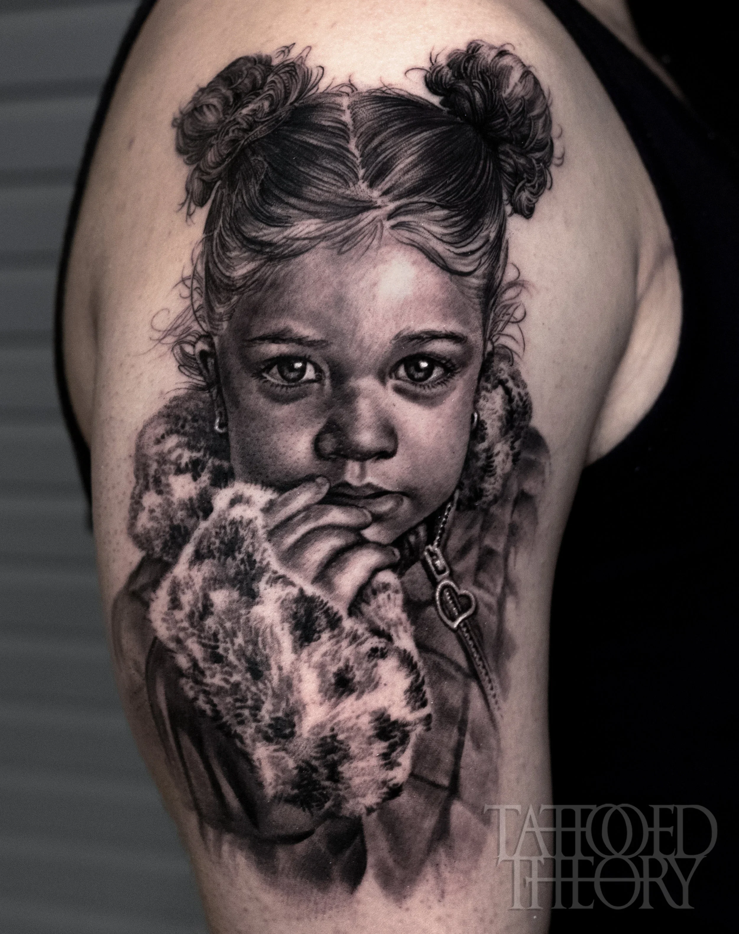 Black and gray tattoo of a woman's face with detailed hair and a leopard print during daytime.