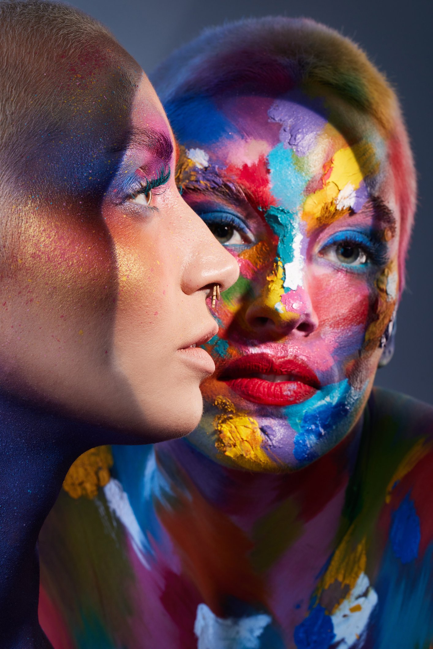 Close-up of two faces with vivid, multicolored face paint.