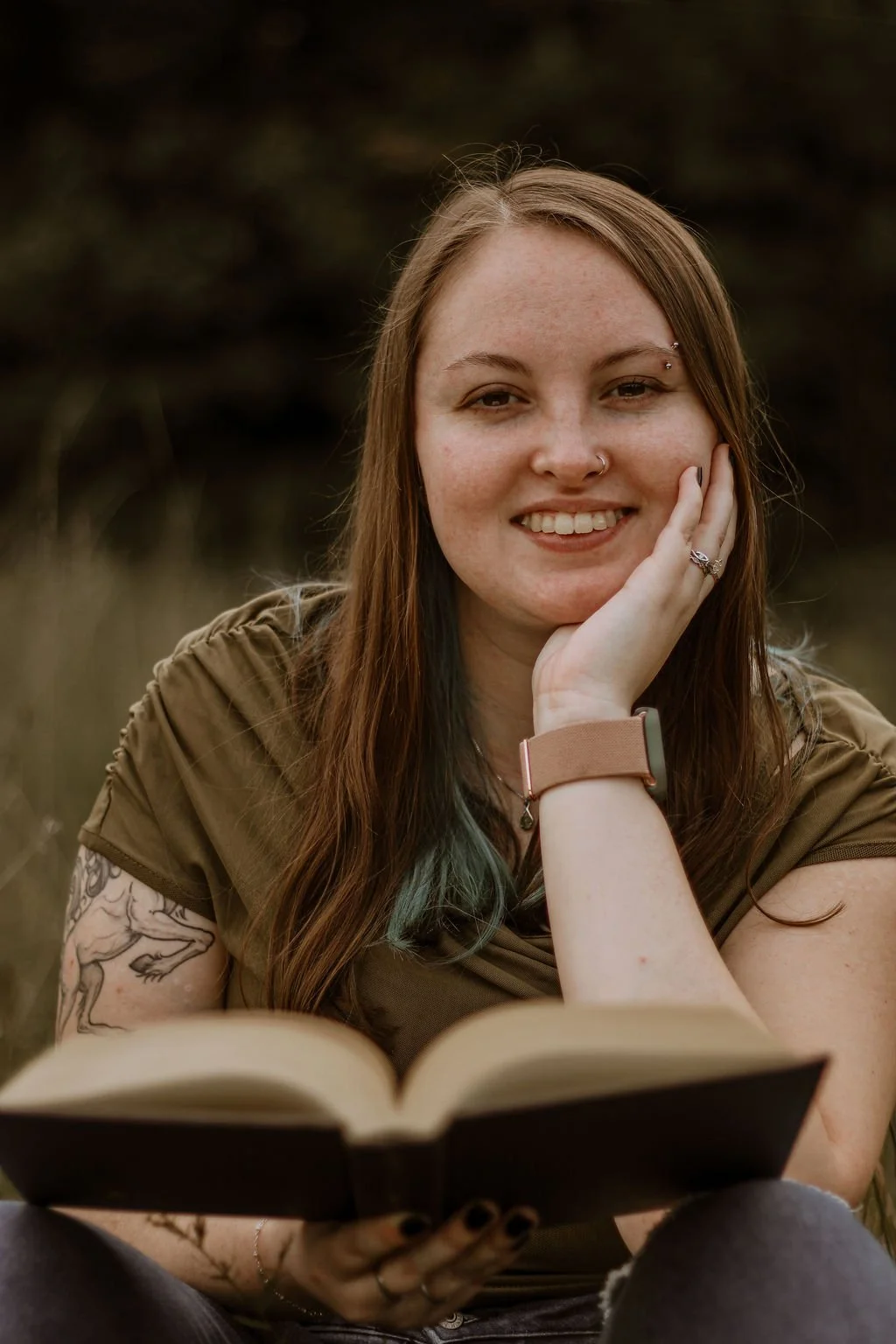 Photo of author in a field holding a book, photographed by Little Tree Photography.