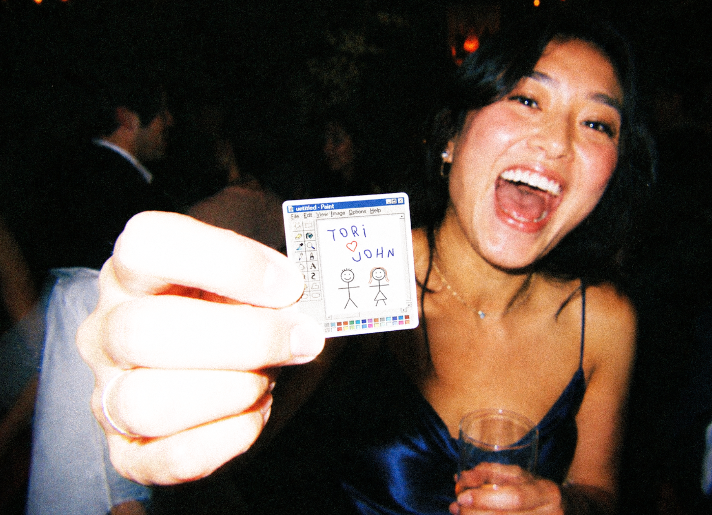 Happy social event guest holding up a custom personalized sticker favor.