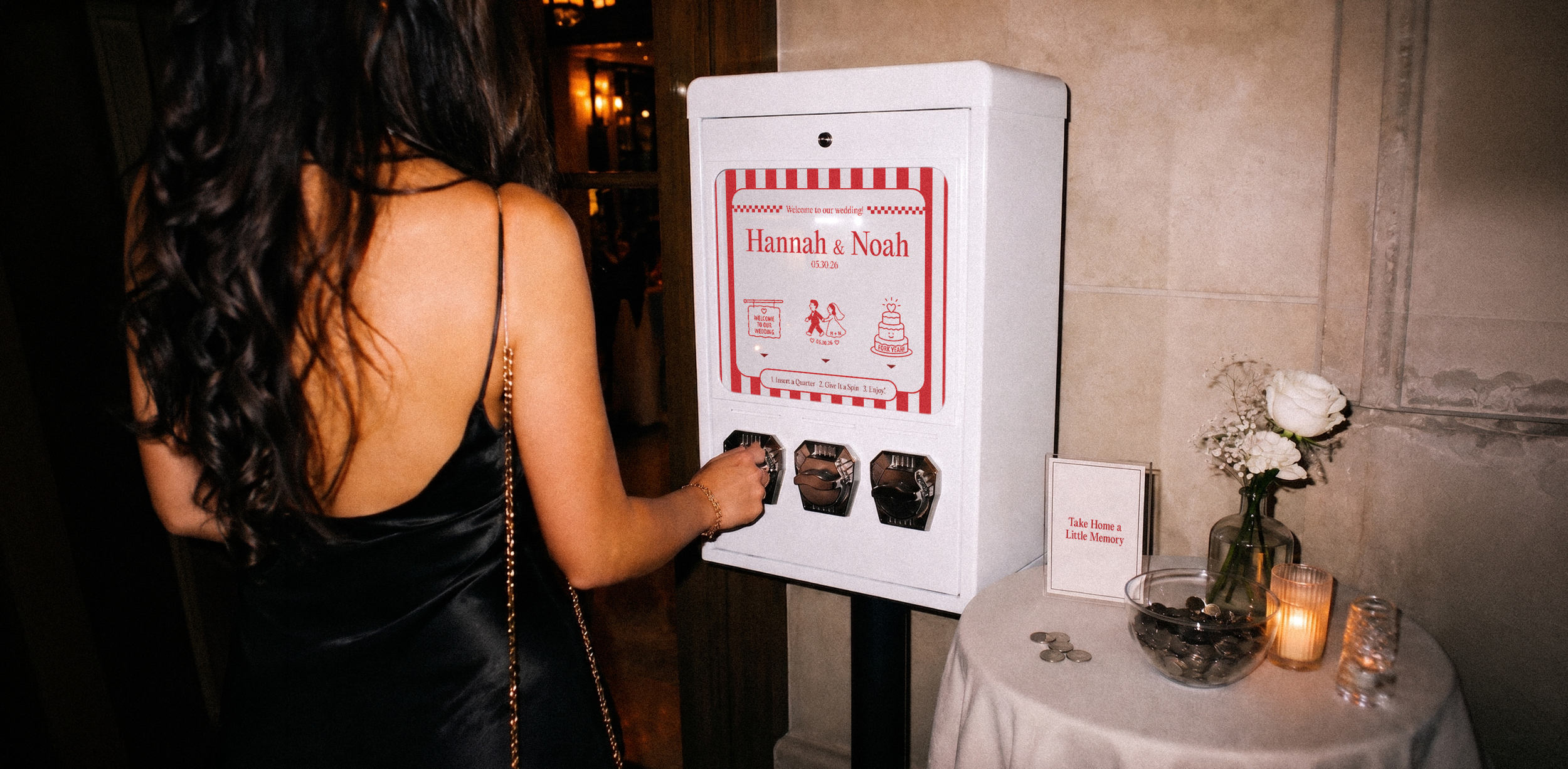 A female guest using a custom white sticker vending machine party favor at a wedding reception.