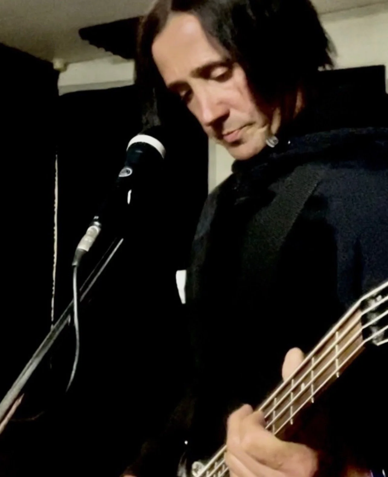 Daniel Paul Calvo playing a bass guitar and singing during a studio recording session.