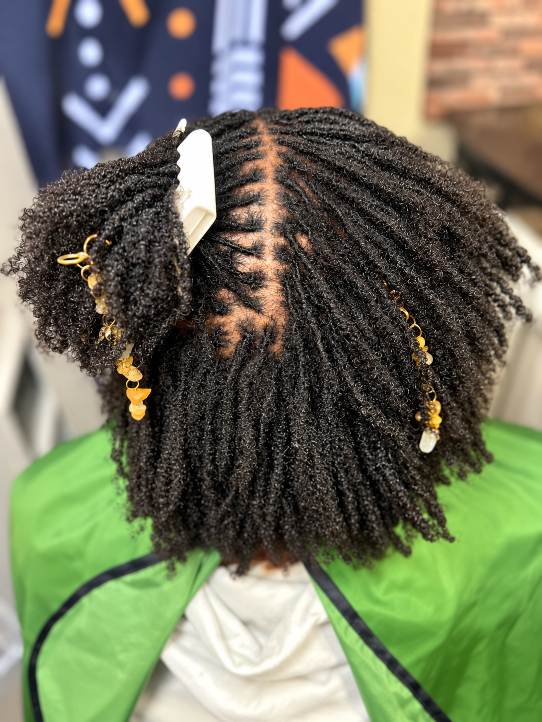 Coiffure en locs avec accessoires dorés.png