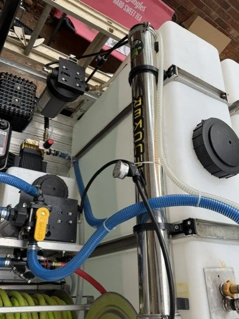 A setup with a white industrial machine, blue hoses, and various attachments, likely used for scientific or industrial purposes.