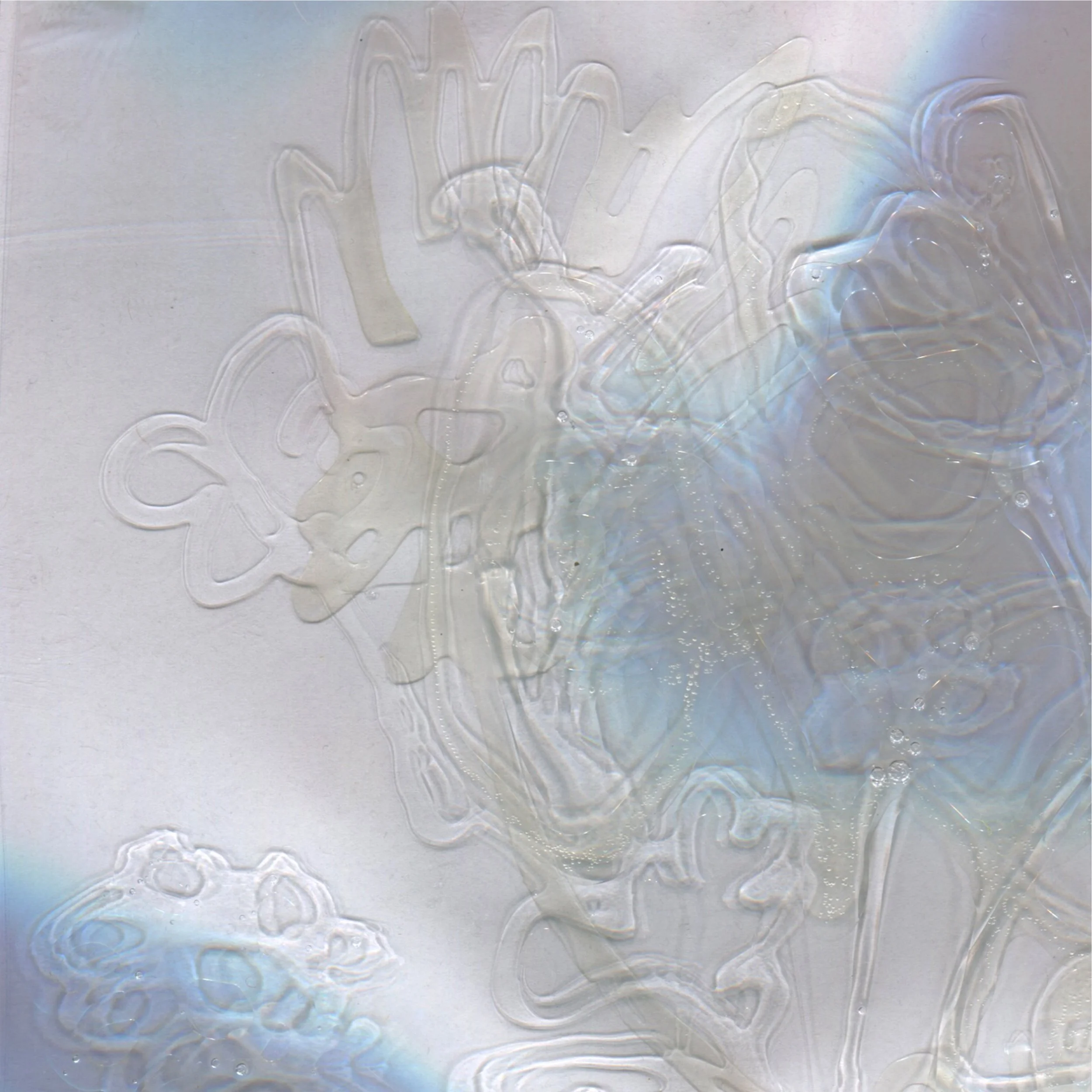 Close-up of a surface with water spray and streaks, creating a pattern of lines and ripples with rainbow-colored reflections.