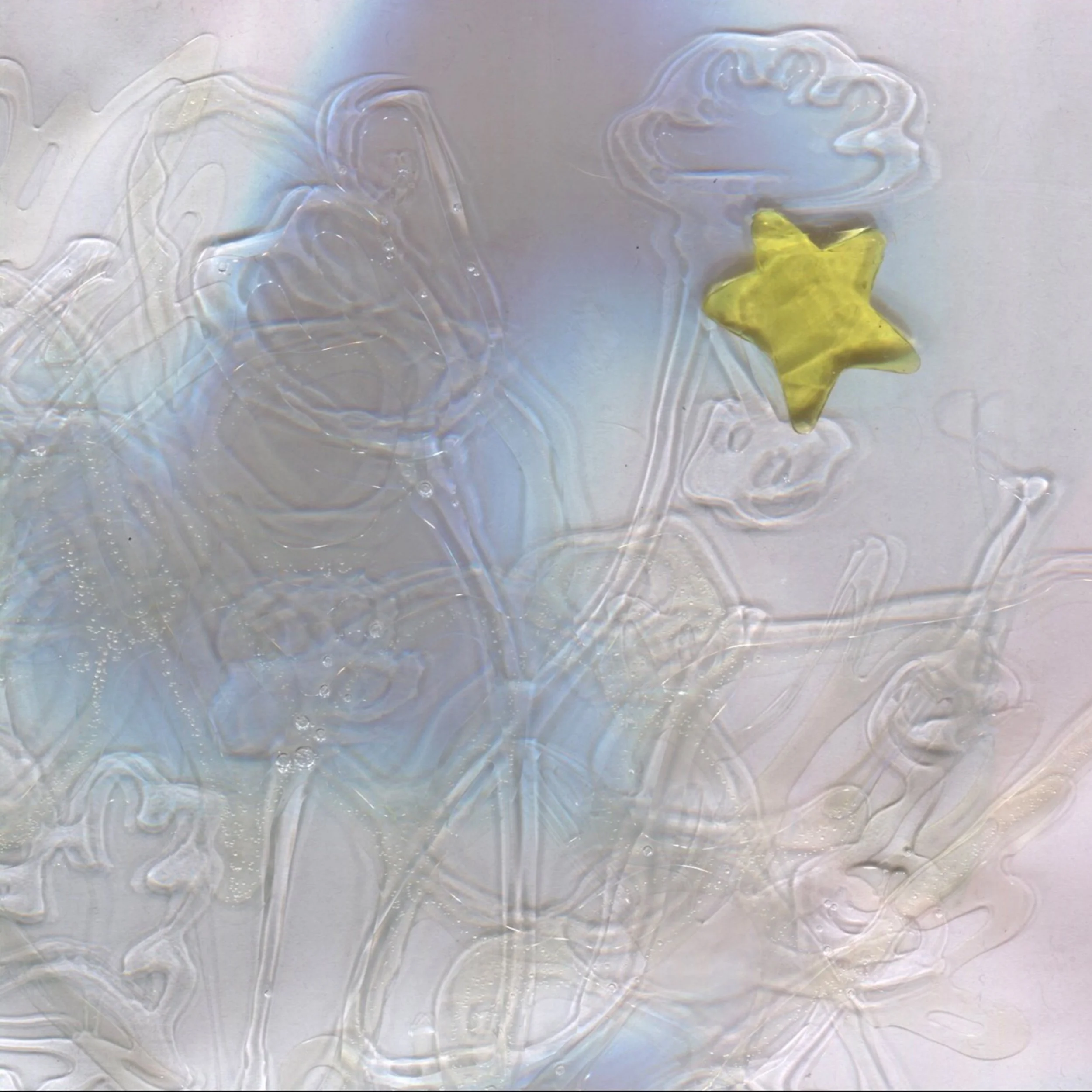 Close-up of an iridescent, shiny surface with an embossing of three dinosaur figures and a yellow star-shaped object on the lower right.