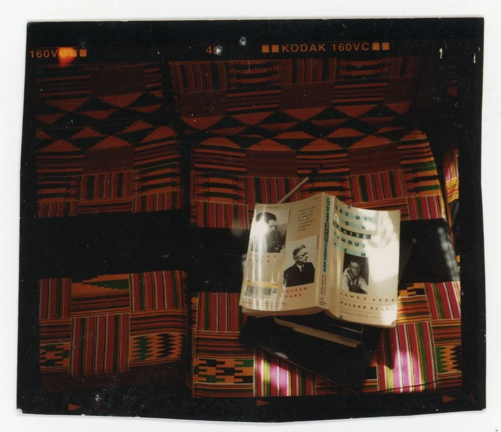 Photograph of a table with a colorful, patterned tablecloth and an open book or pamphlet on top of it.