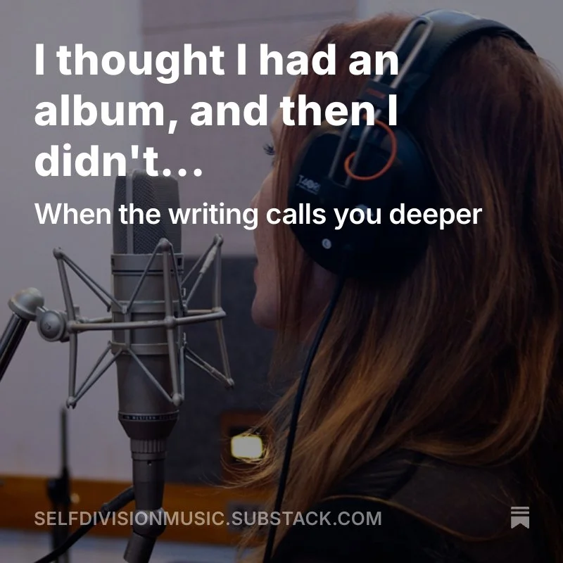A woman with long red hair wearing headphones singing into a microphone in a recording studio.