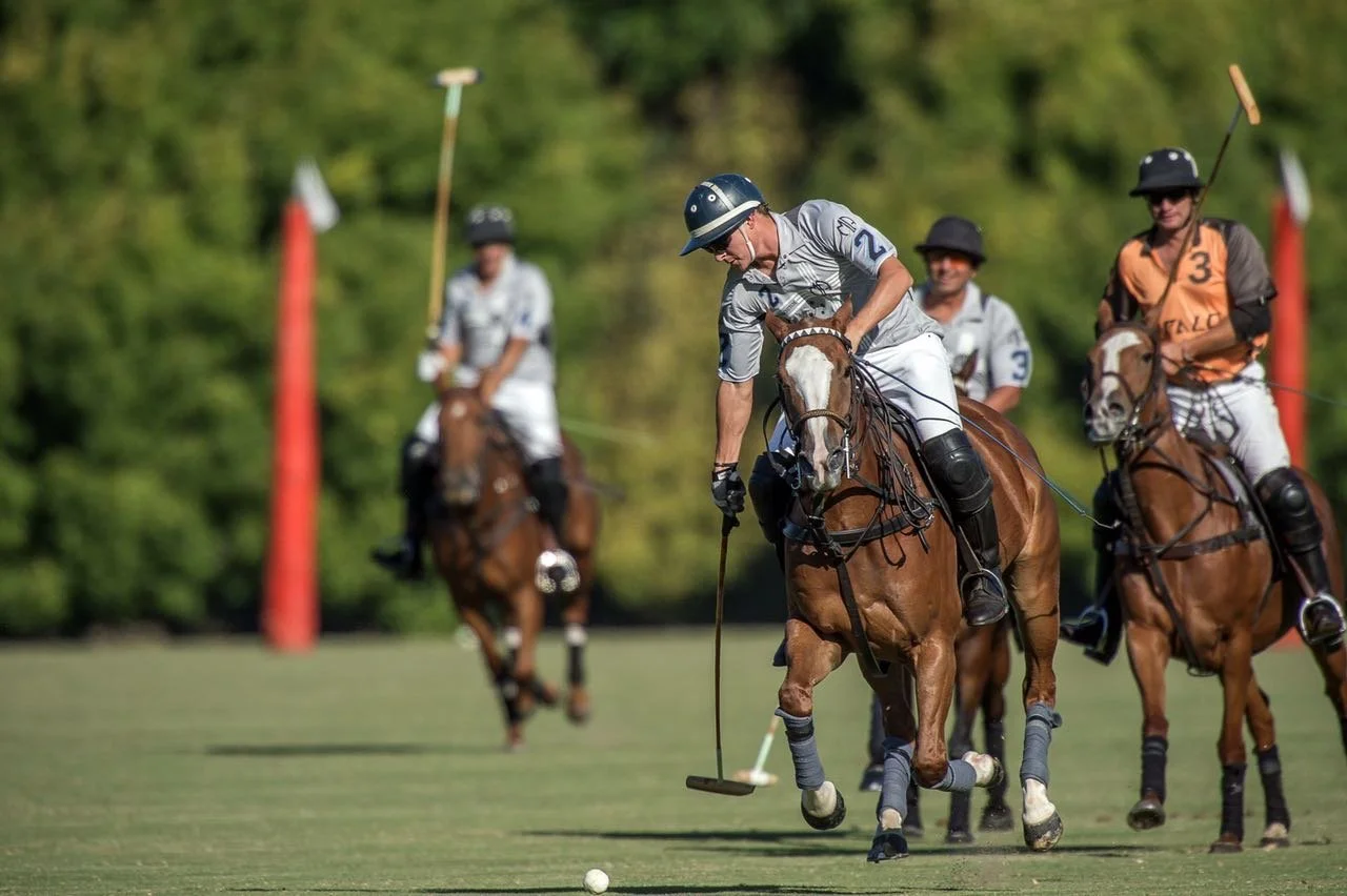 Polo players on horseback competing on a field during a game